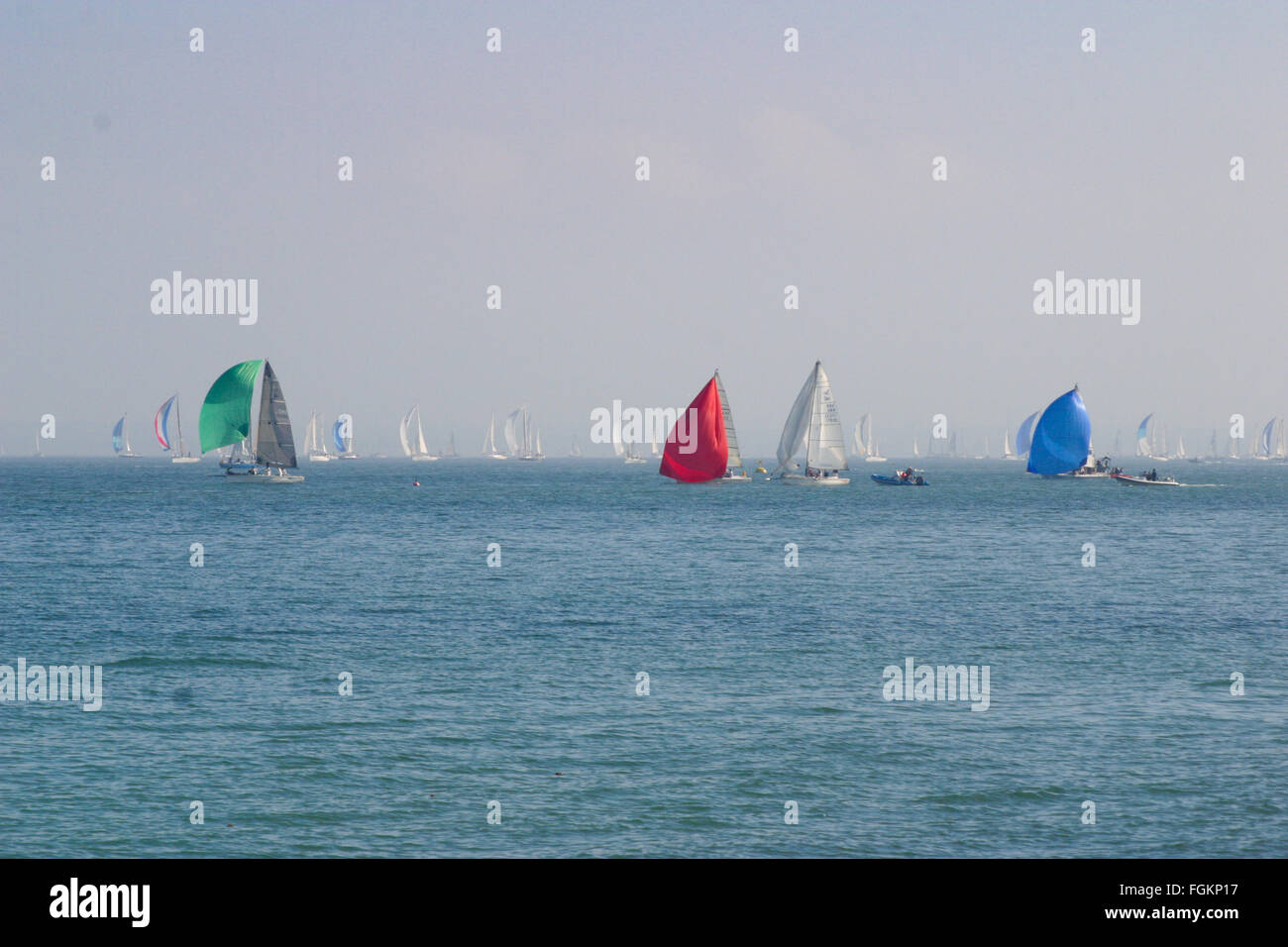 Un gruppo di racing yachts in una giornata di sole con primari colore colore spinnaker il giro dell'isola, Isola di Wight regata a vela REGNO UNITO Foto Stock