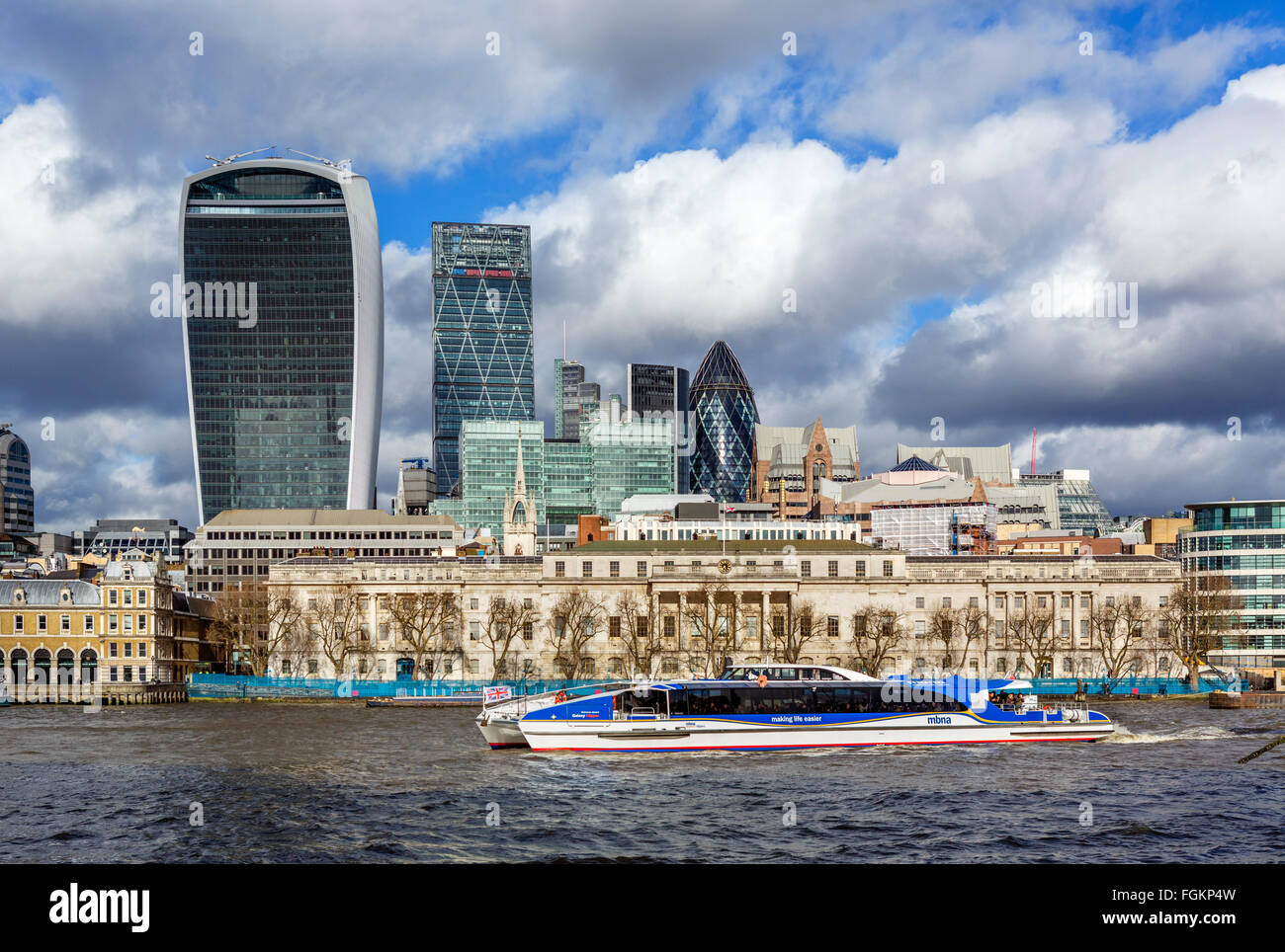 Vista sul Tamigi per la città di Londra con Custom House e MBNA Thames Clipper in primo piano, London, England, Regno Unito Foto Stock