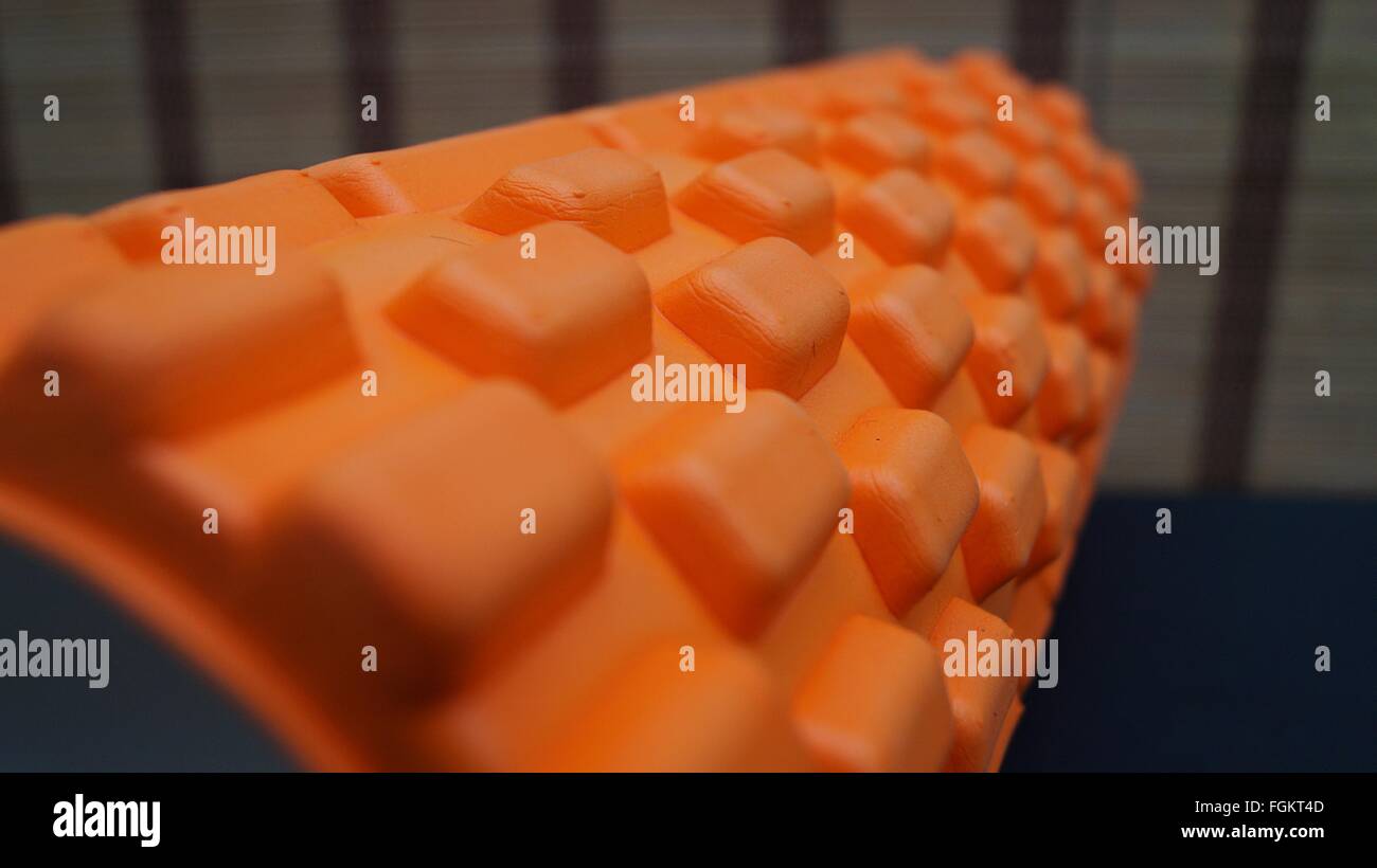 Primo piano delle creste sul supporto fitness con rullo in schiuma arancione Foto Stock