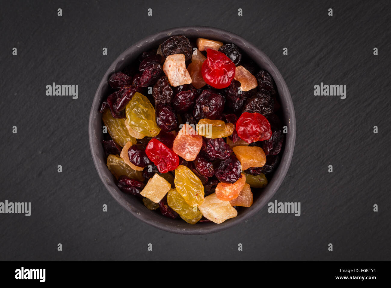 Mix varietà di frutta secca in coppa sopra il nero scuro dello sfondo di pietra Foto Stock