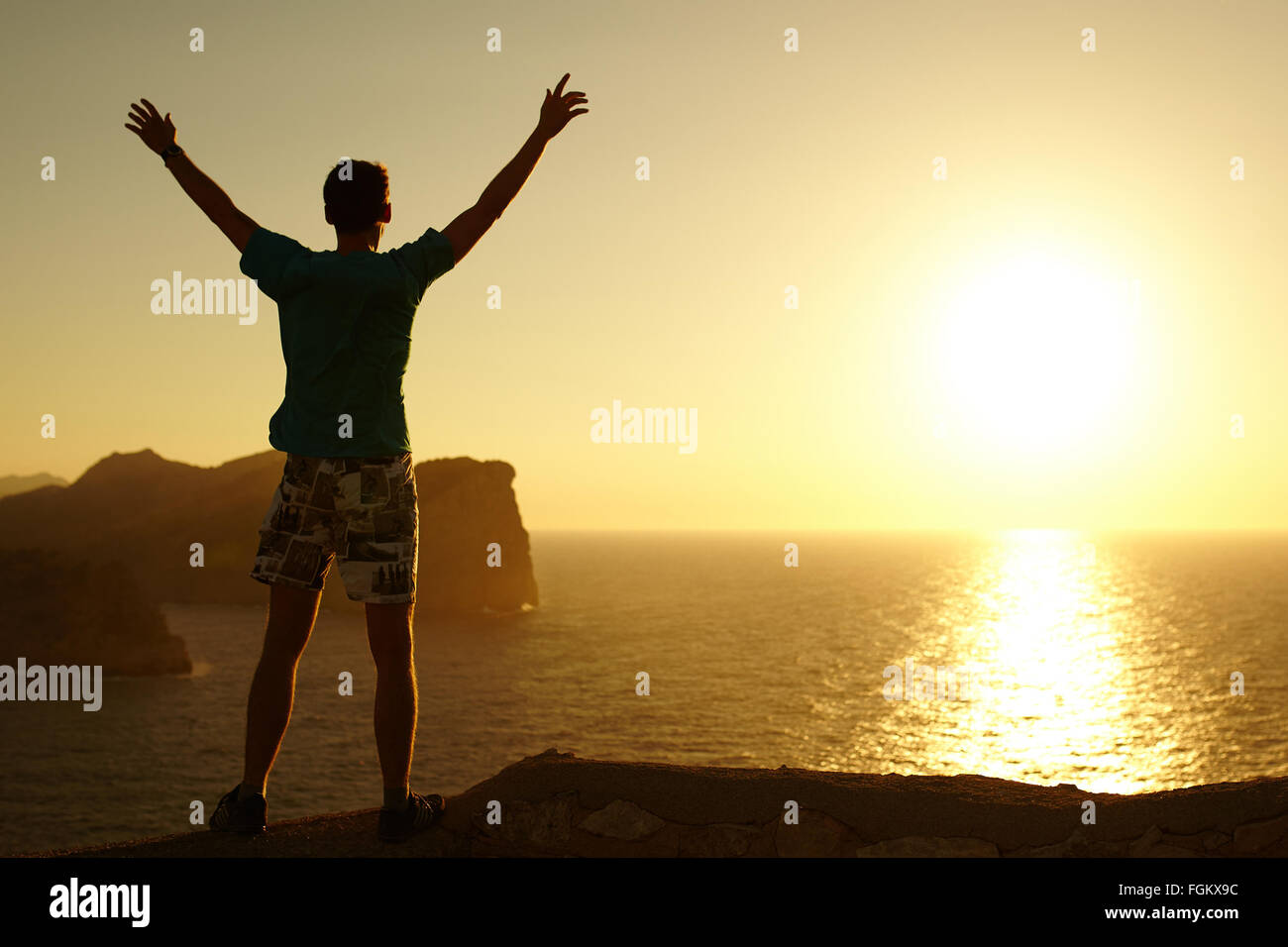 Silhouette di un giovane con le mani alzate Foto Stock