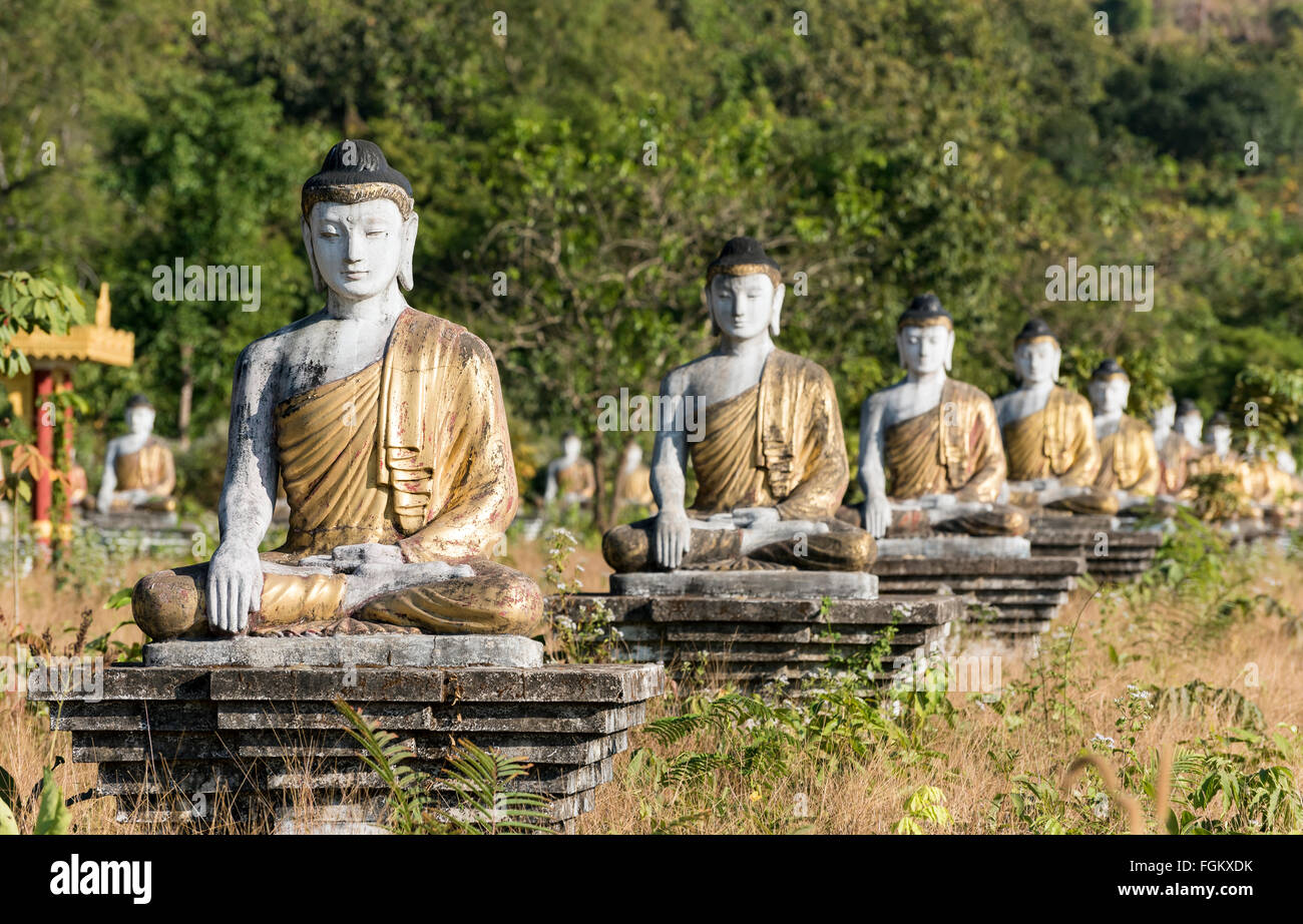 Fila di statue di Buddha a Lumbini giardino sotto il monte Zwegabin, di Hpa-an, Karen (Kayin) Stato, Birmania Foto Stock