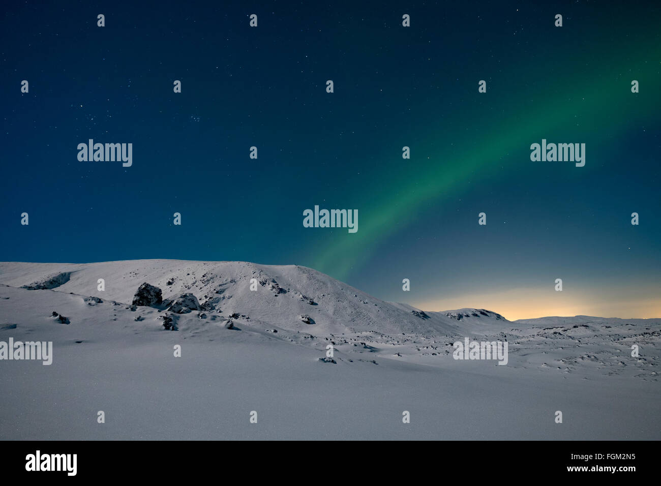 Luci del nord nel cielo di montagne coperte di neve Foto Stock