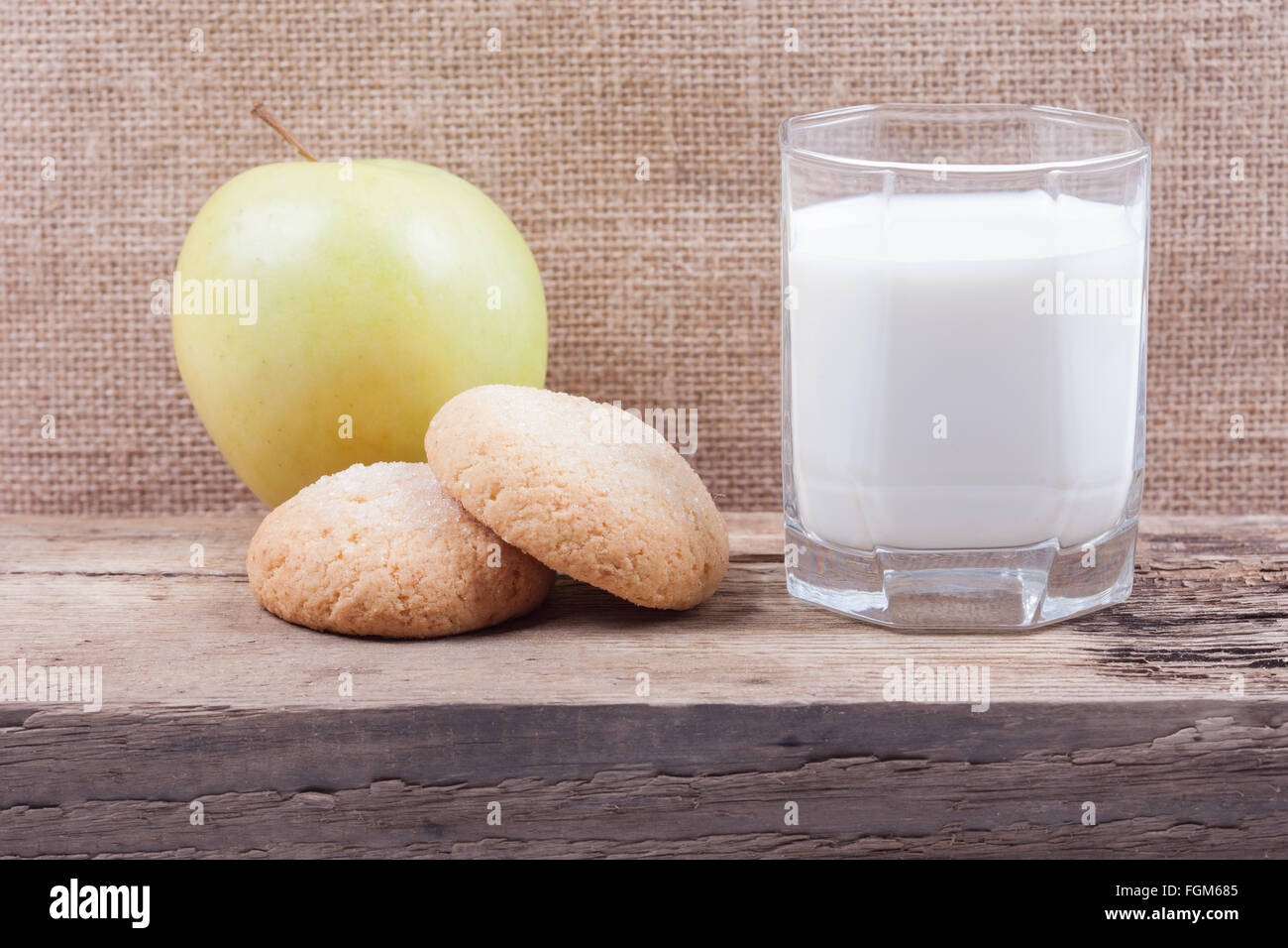 Un bicchiere di latte, Apple e i cookie sul pannello di legno Foto Stock