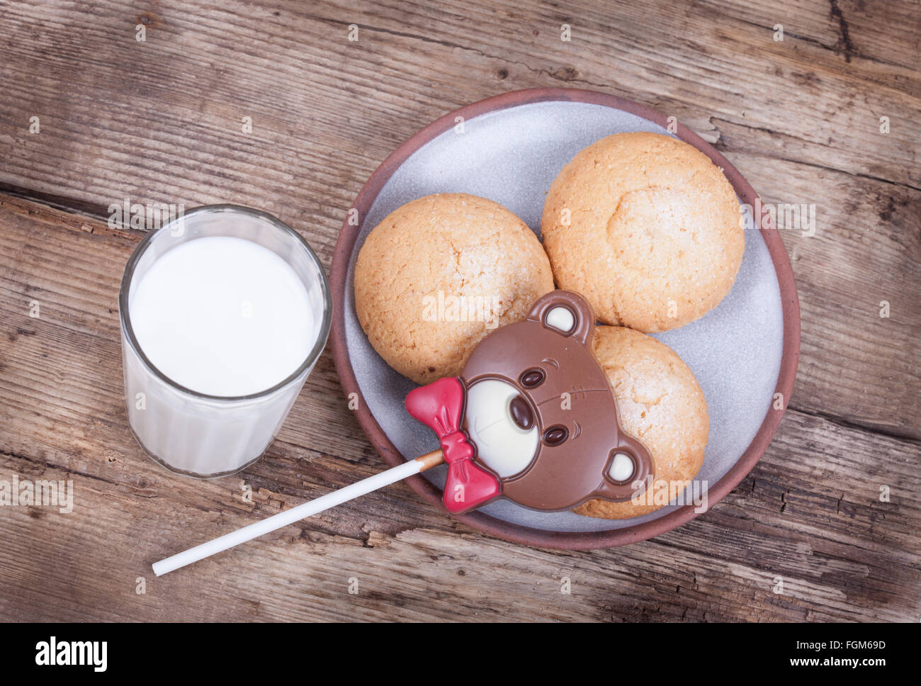 Orso di cioccolata, biscotti, latte, legno rustico vista dall'alto lo sfondo Foto Stock