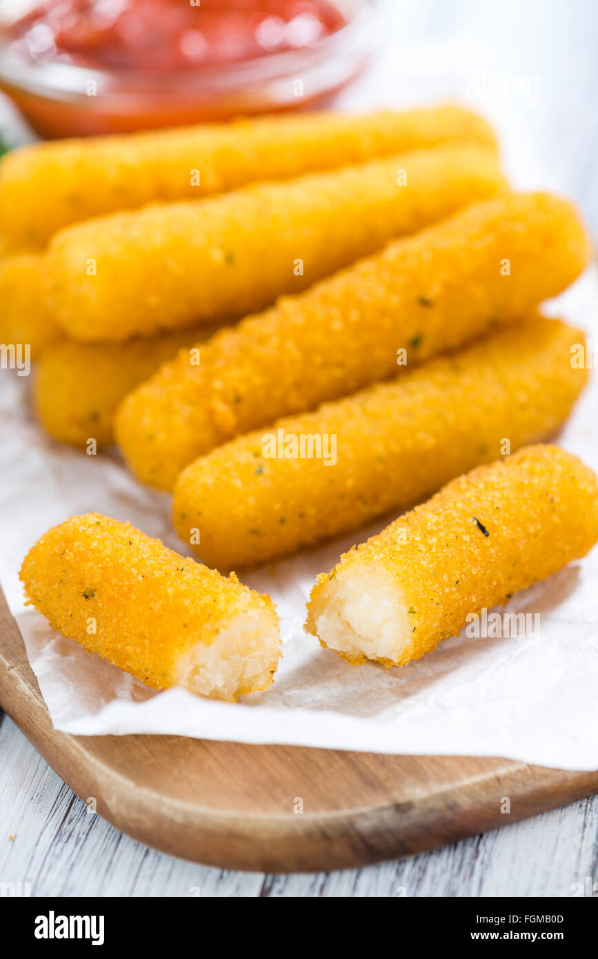 Porzione di bastoncini di mozzarella su un vecchio tavolo di legno (messa a fuoco selettiva) Foto Stock