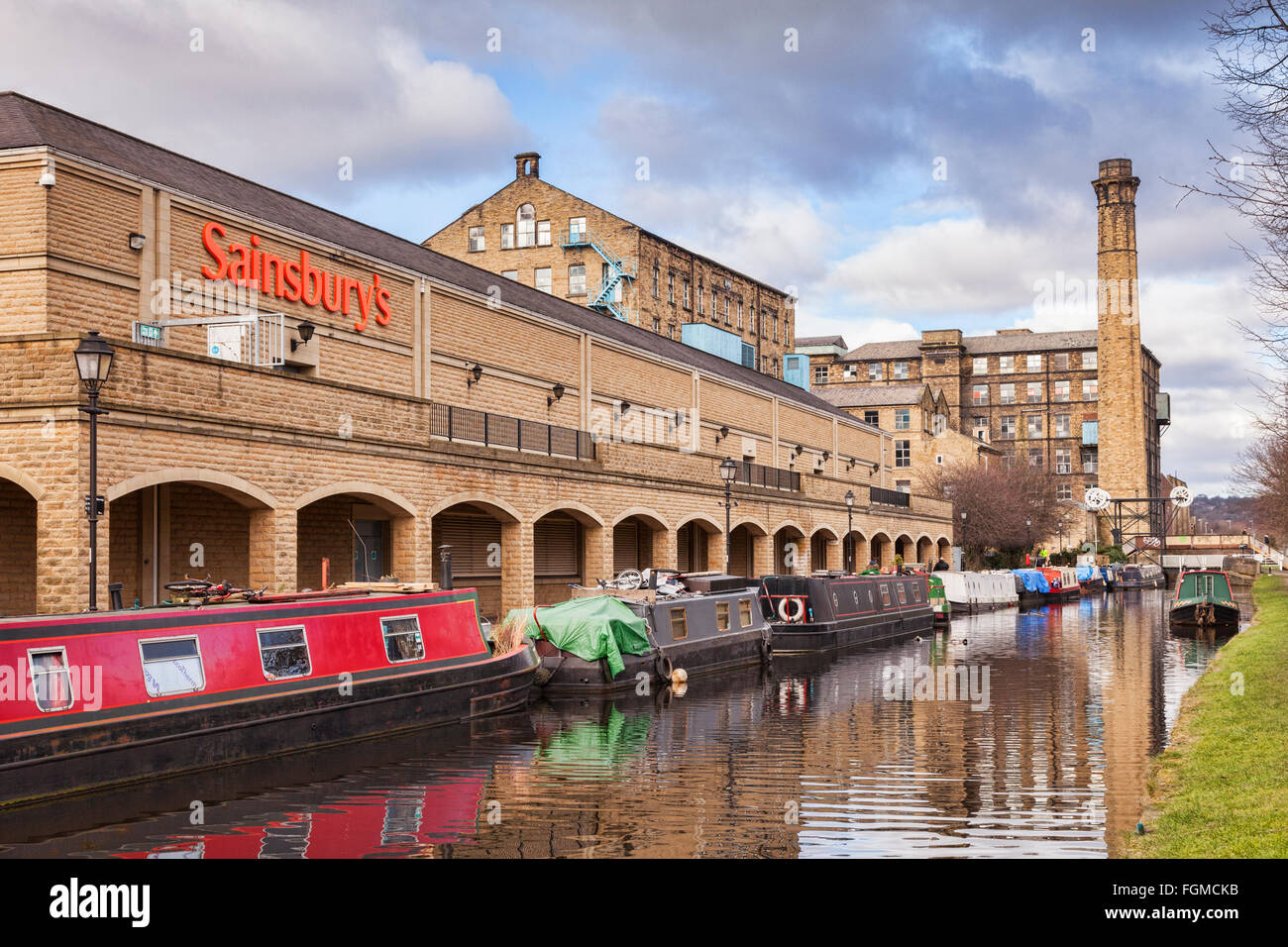 Narrowboats Ormeggiato accanto a Sainsbury's sulla Huddersfield ampia Canal, Huddersfield, West Yorkshire, Inghilterra, Regno Unito Foto Stock