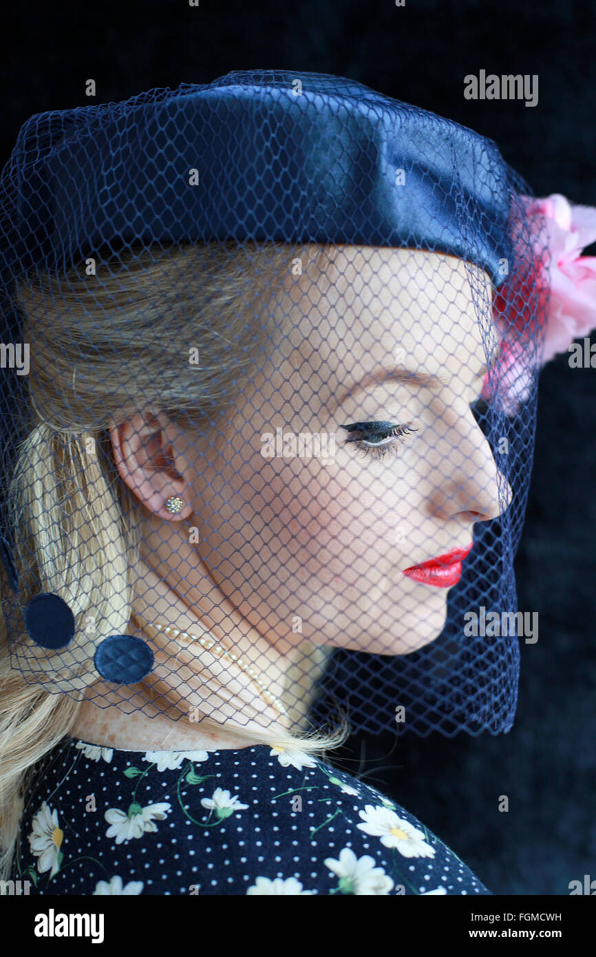 Bellissima 1940s giovane donna che indossa un cappello con un velo Foto Stock