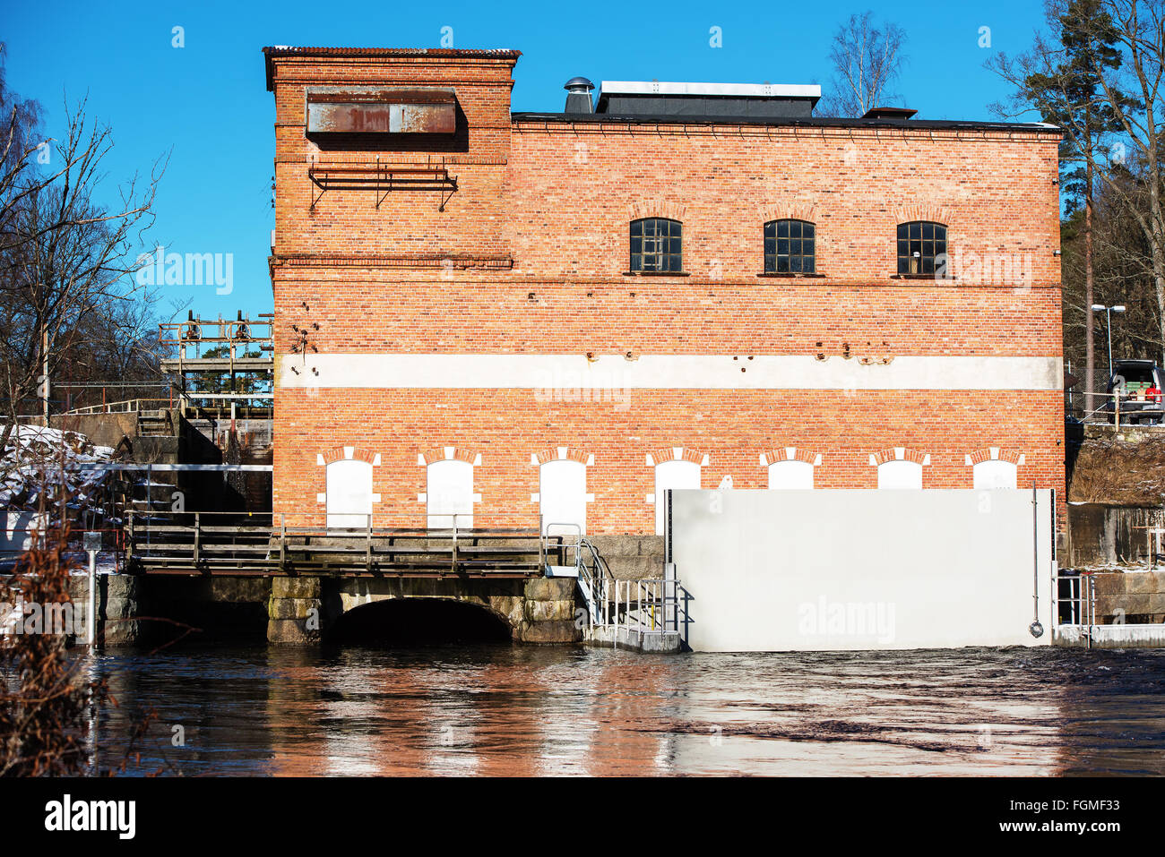 Fridafors, Svezia - 16 Febbraio 2016: l'acqua cancelli sono aperti in corrispondenza della piccola scala locale di potenza idroelettrica. Edificio i Foto Stock