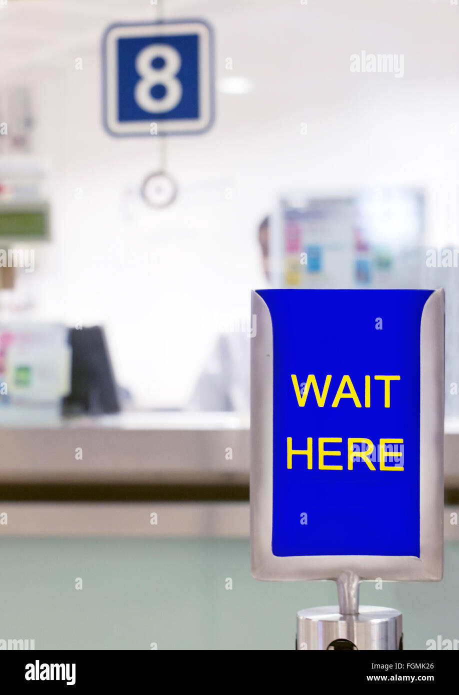 Segno con il testo ATTENDERE qui prima che il contatore Foto Stock