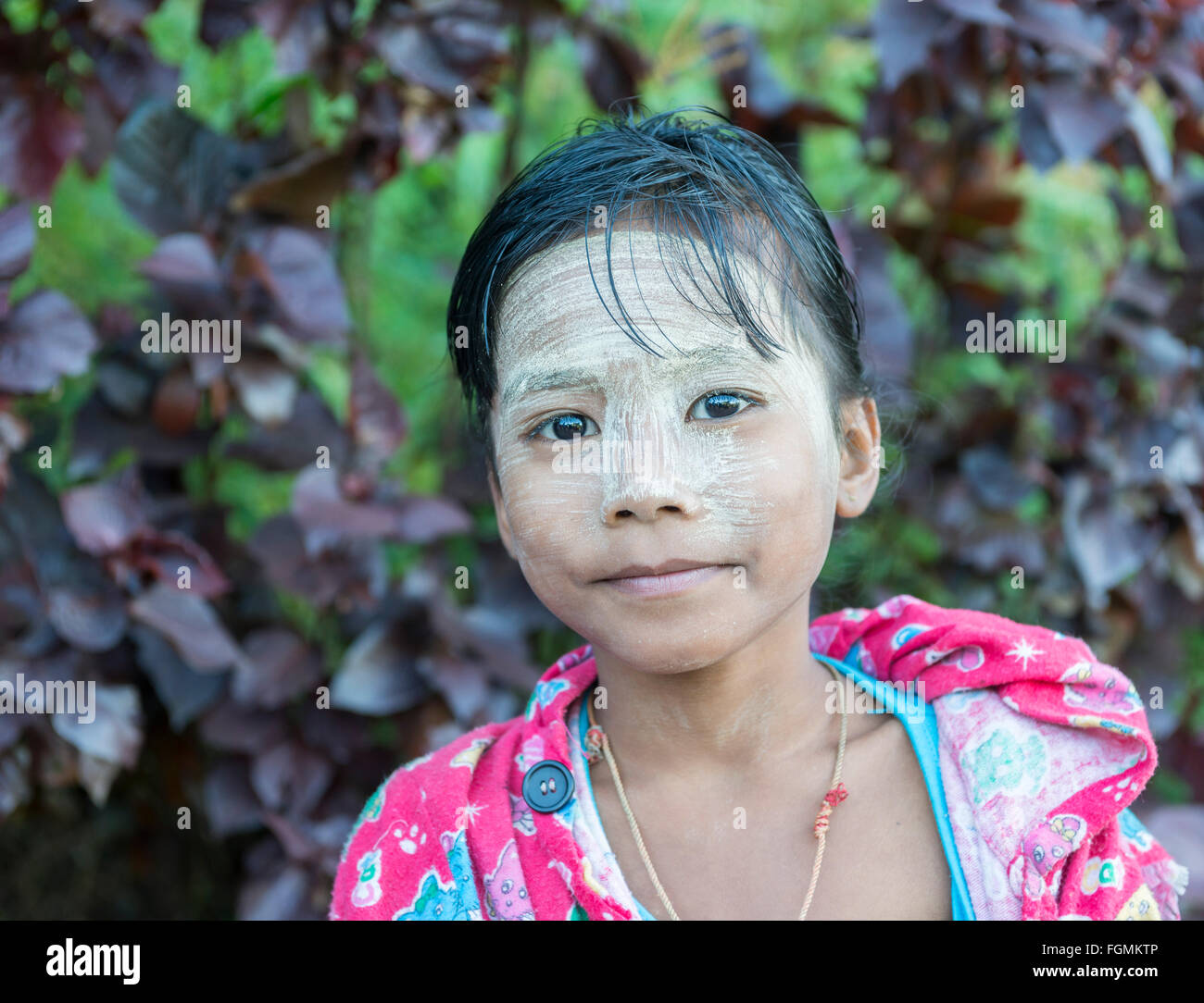 Ragazza giovane con la faccia dipinta, Birmania Foto Stock