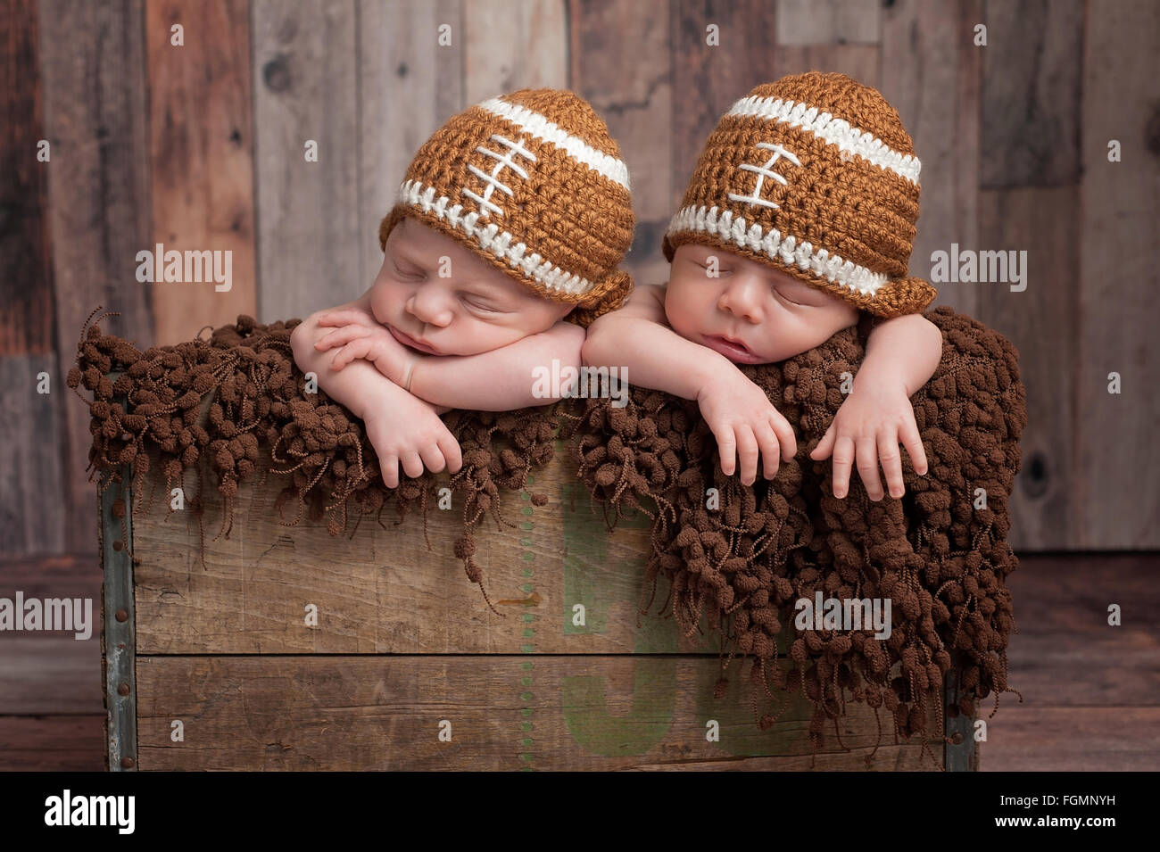 Twin Baby Boys indossando a forma di pallone da football cappelli Foto Stock