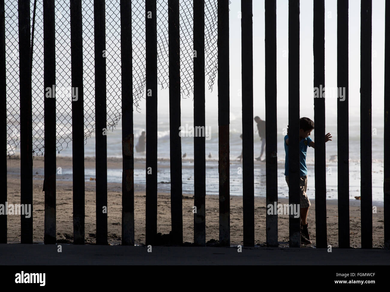 Un ragazzo coetanei attraverso la recinzione di confine come visto dal lato americano US / Tijuana, Messico confine vicino San Ysidro, California Foto Stock