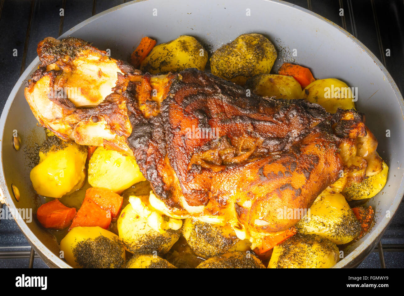 Cotta al forno a gamba di maiale con patate e spezie Foto Stock