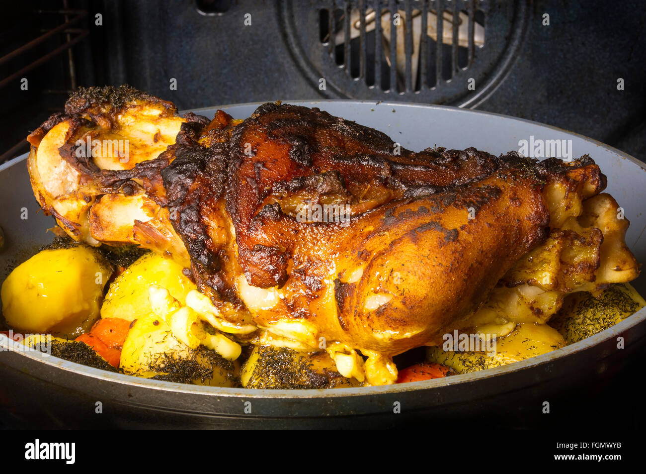 Cotta al forno a gamba di maiale con patate e spezie Foto Stock