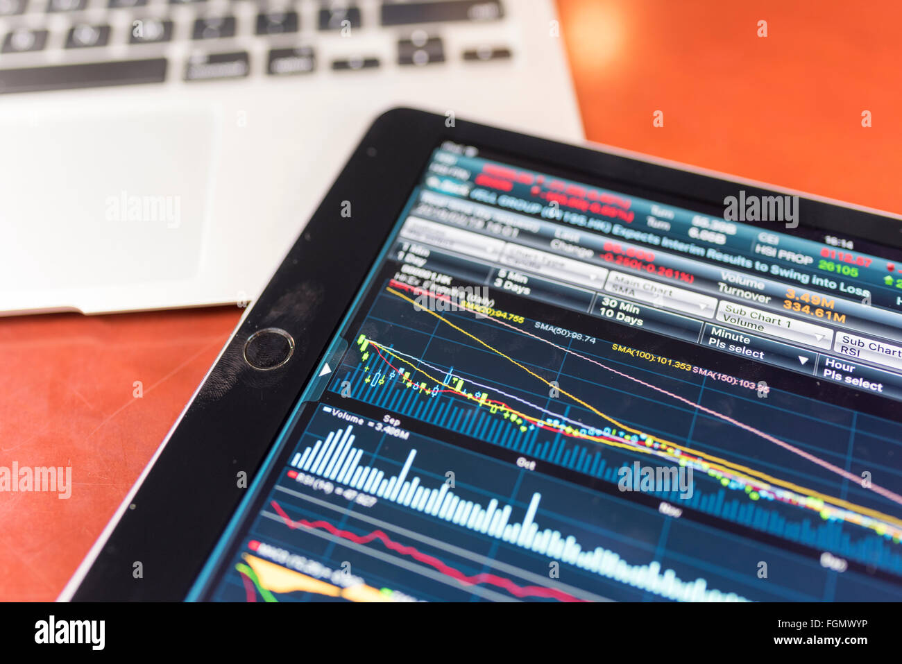 Magazzino grafico su tablet con un portatile su una tavoletta di legno Foto Stock