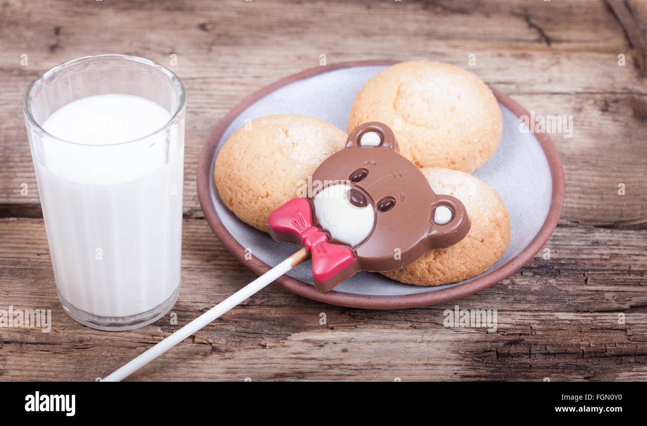 Dolce di Cioccolato orso, biscotti, latte, Sfondo legno Foto Stock
