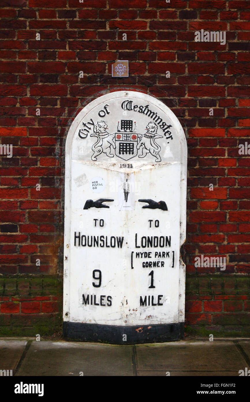 Old Mile post datato 1911 con una versione dello stemma originale della City of Westminster con un portcullis, Kensington High Street, Londra, Inghilterra Foto Stock
