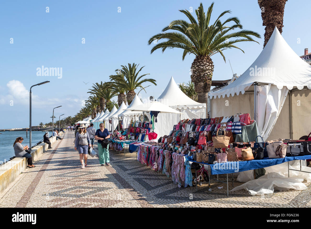 Le persone sul lungomare con le bancarelle del mercato di Lagos, Algarve, PORTOGALLO Foto Stock