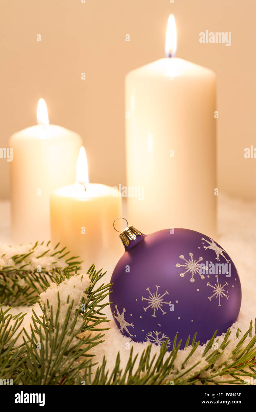 Viola palla di Natale con ornamenti e con candele di accensione sulla neve Foto Stock