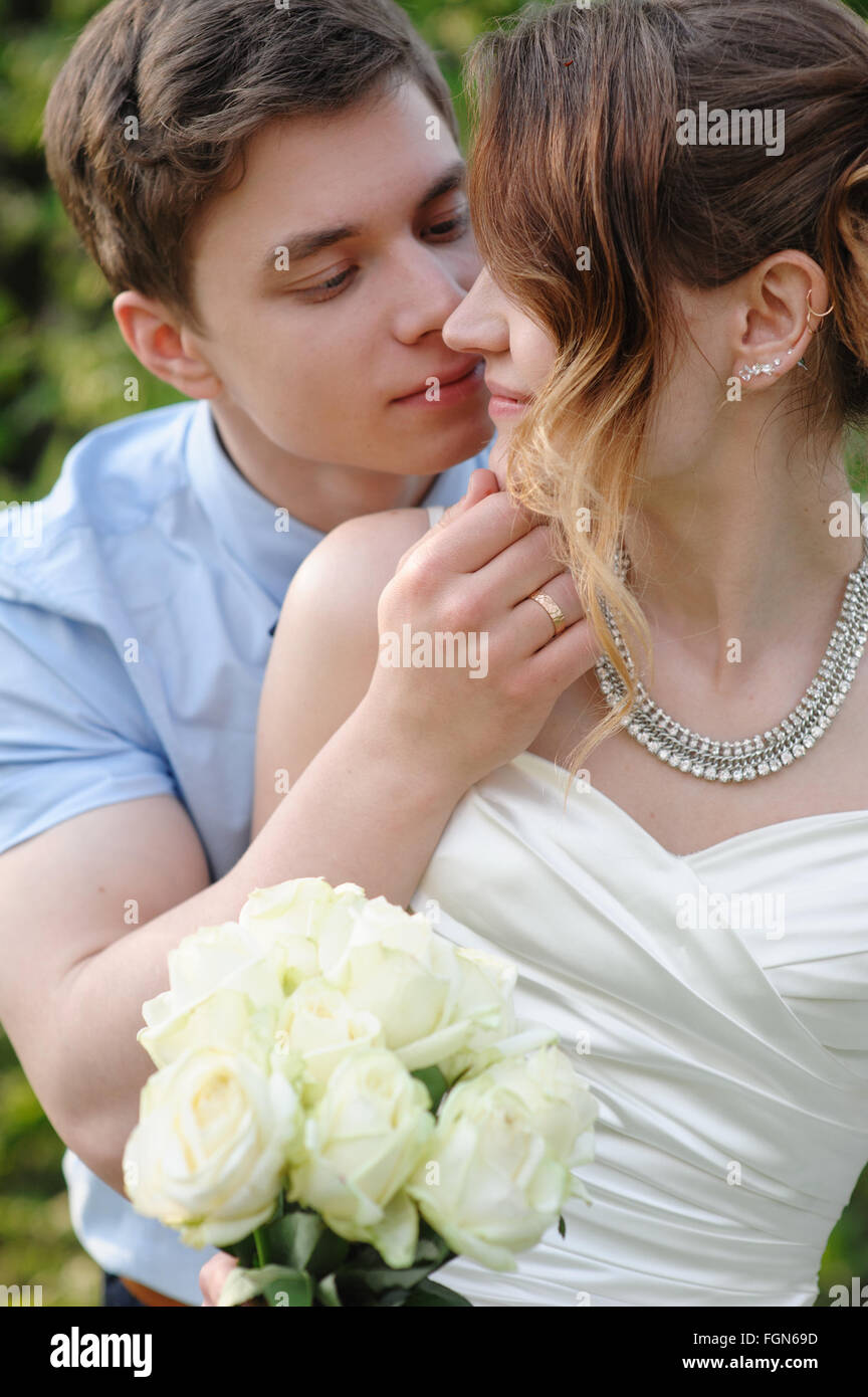Sposa e lo sposo bacio nel giardino di primavera Foto Stock