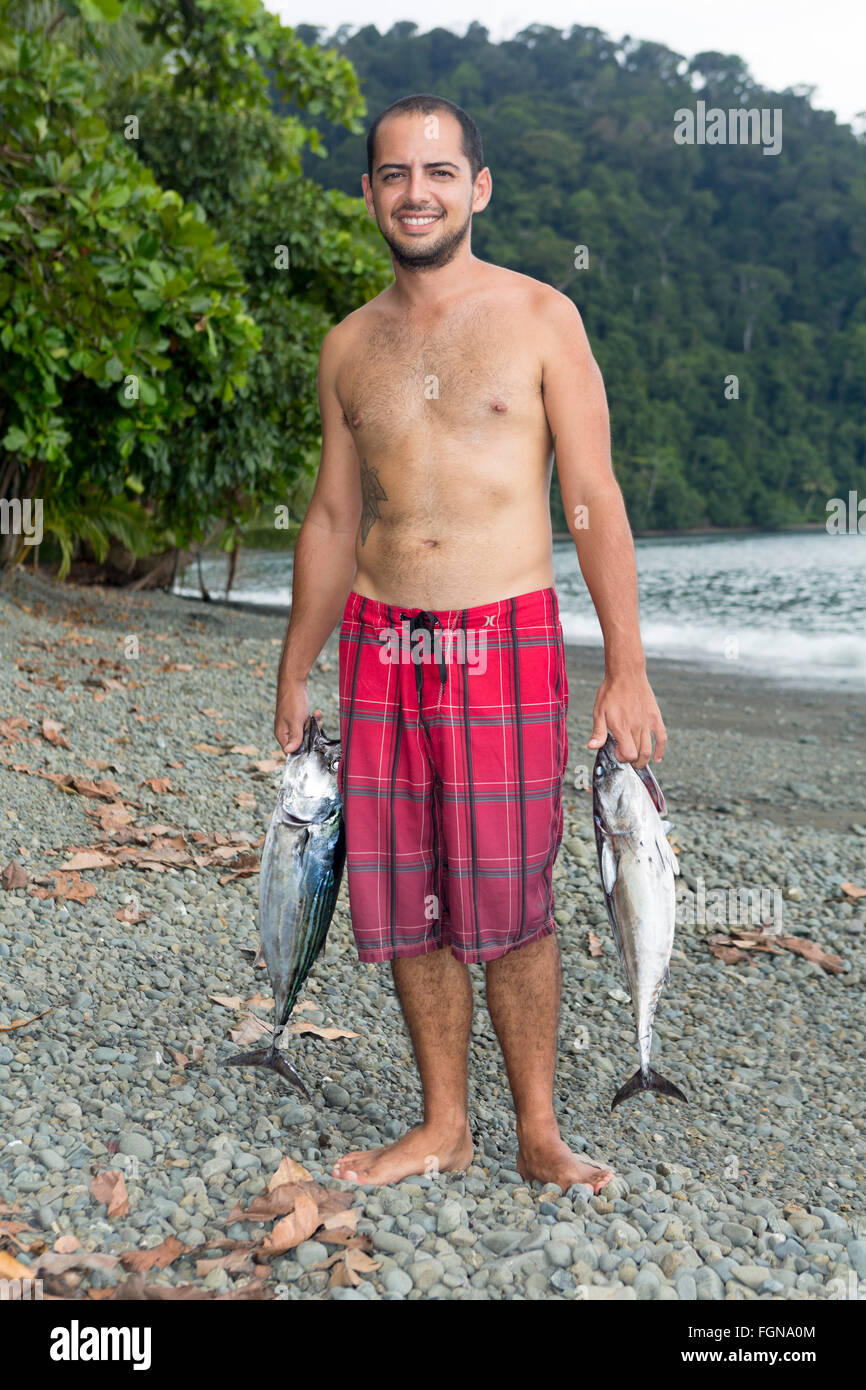 Una Costa Rican pescatore con due appena pescato il tonnetto striato Foto Stock