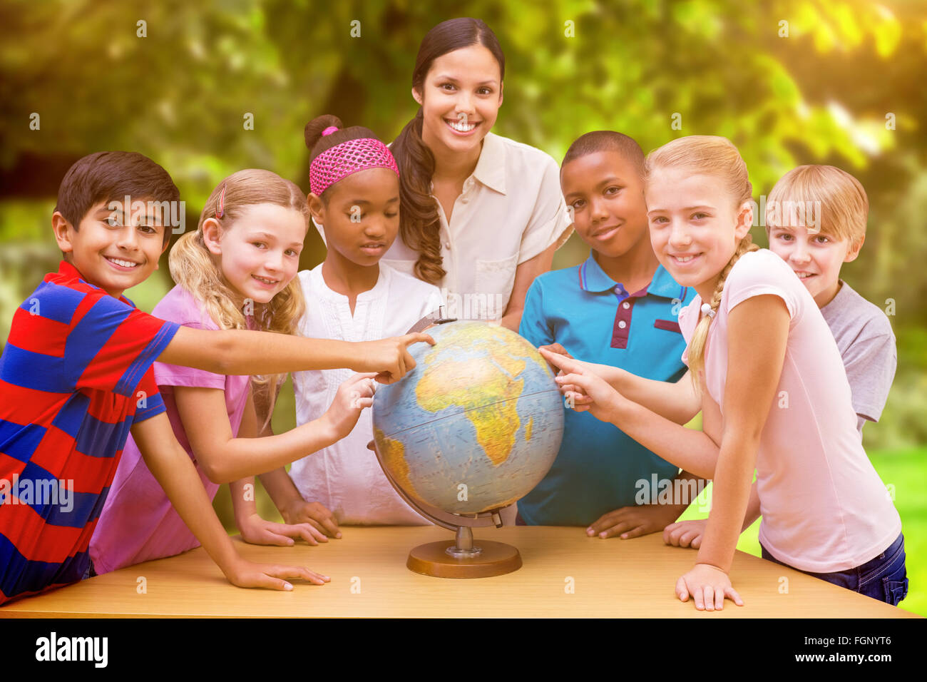 Immagine composita di graziosi gli alunni e gli insegnanti guardando il globo in biblioteca Foto Stock