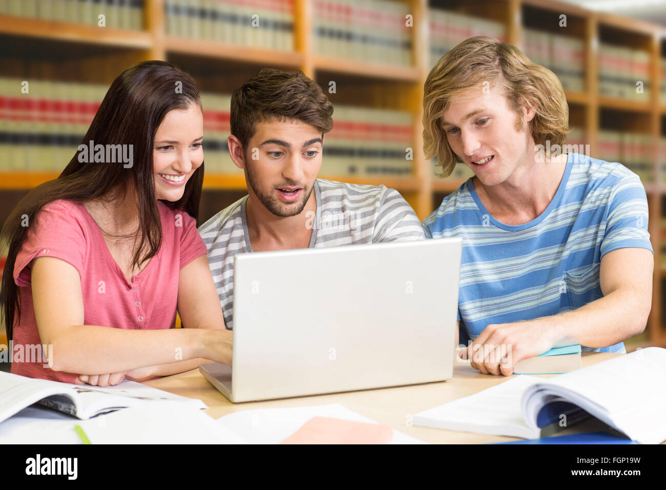 Immagine composita del collegio di studenti che usano il computer portatile in biblioteca Foto Stock