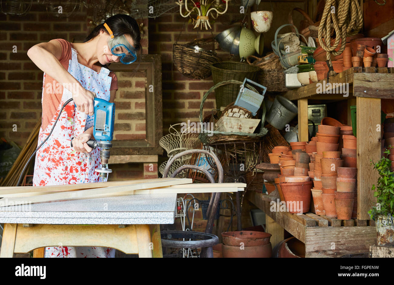 Donna con power sander in officina Foto Stock