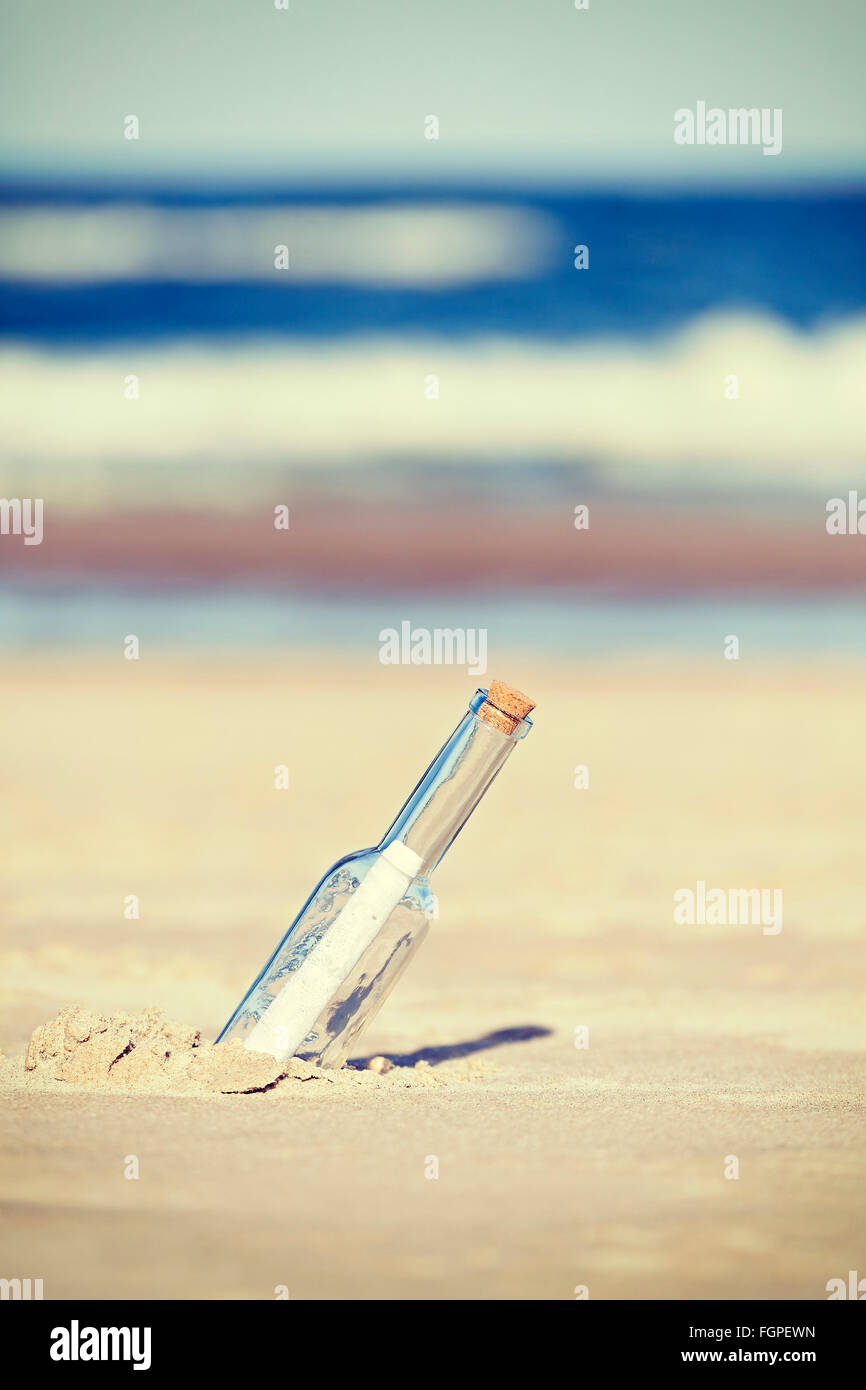 Vintage tonica un messaggio in bottiglia sulla spiaggia, profondità di campo. Foto Stock