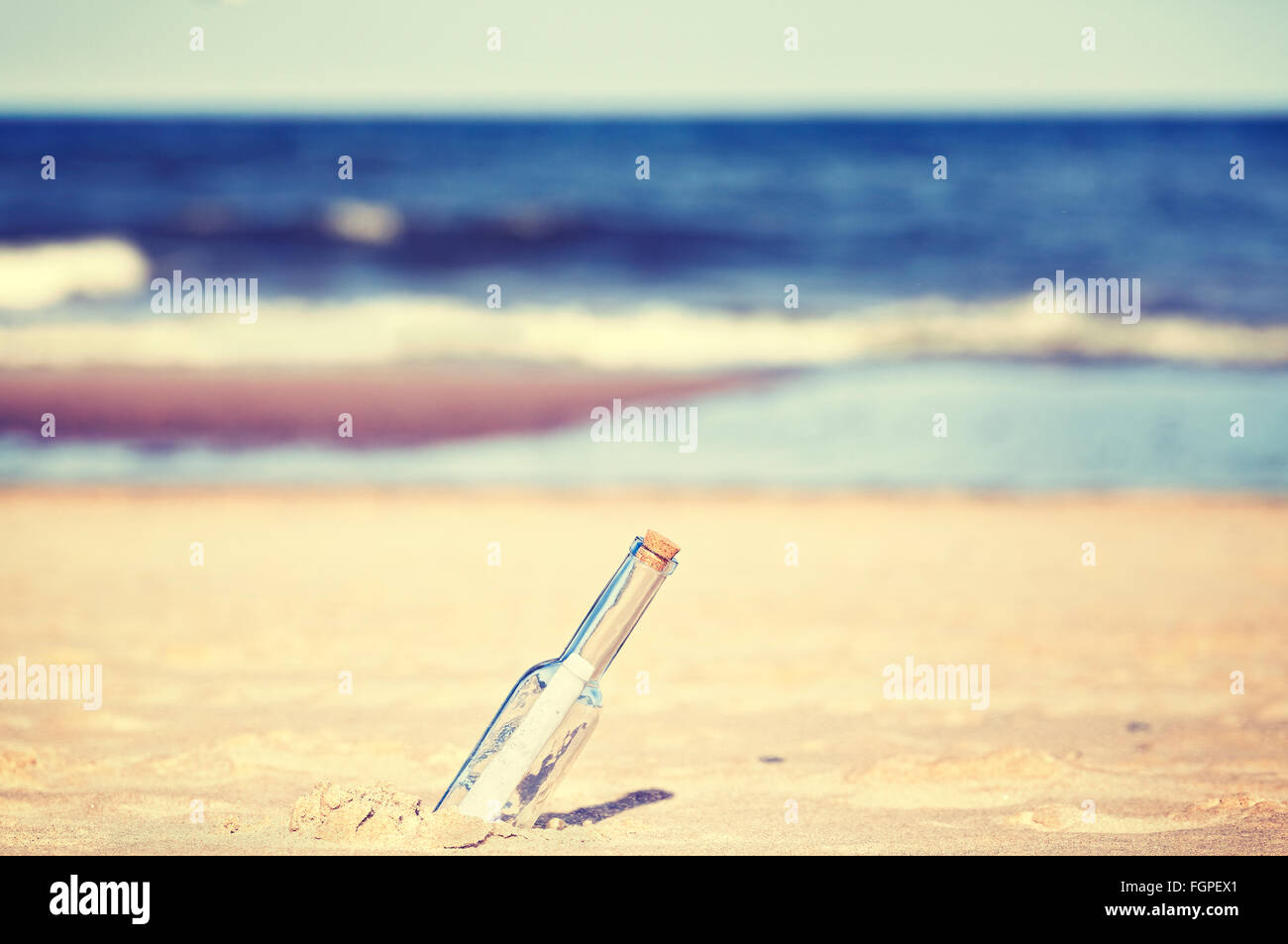 Vintage tonica un messaggio in bottiglia sulla spiaggia, profondità di campo. Foto Stock