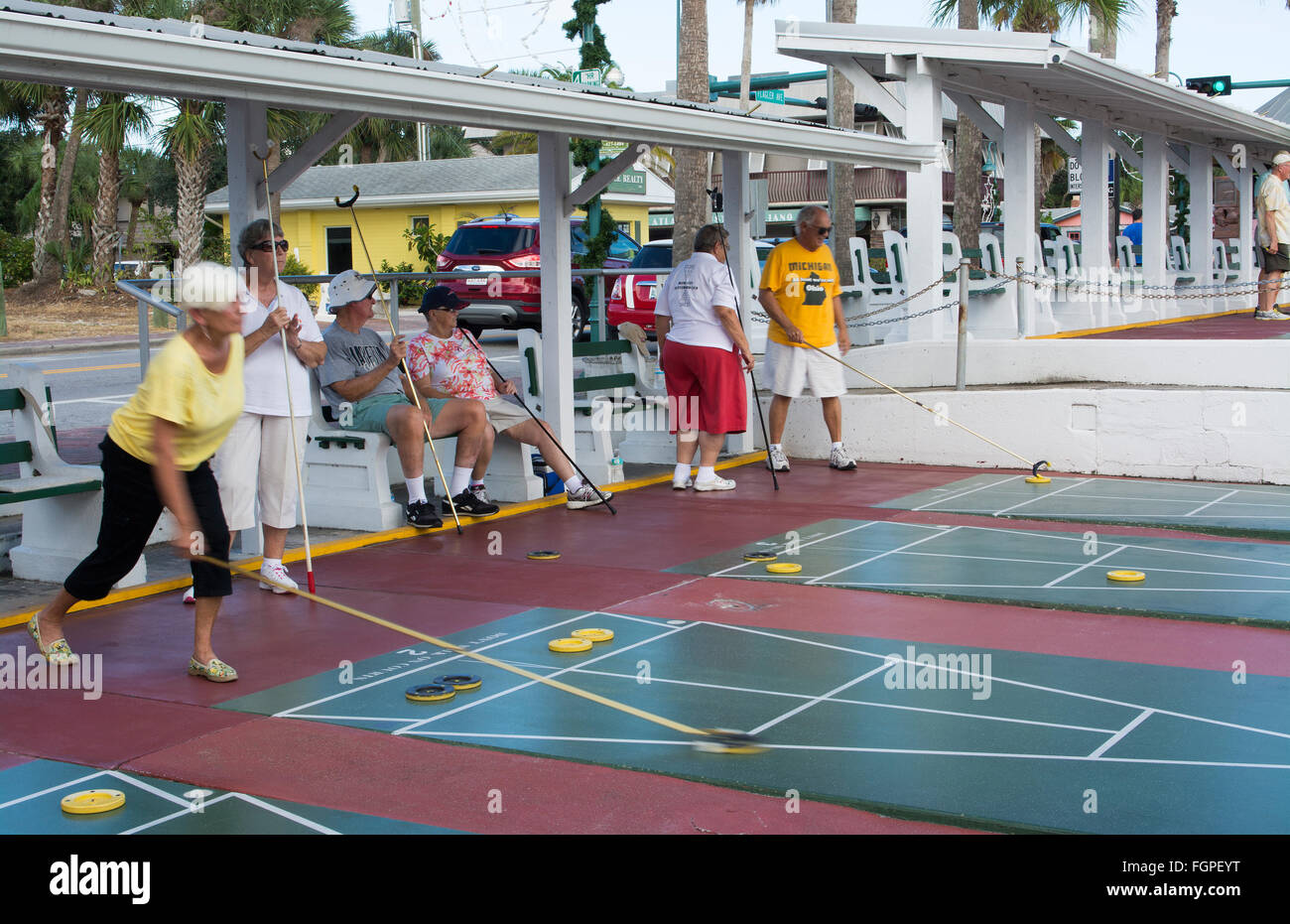 New Smyrna Beach Florida senior coppie di pensionati giocando shuffleboard in gioco la concorrenza in città sulla strada Flaglaer Foto Stock