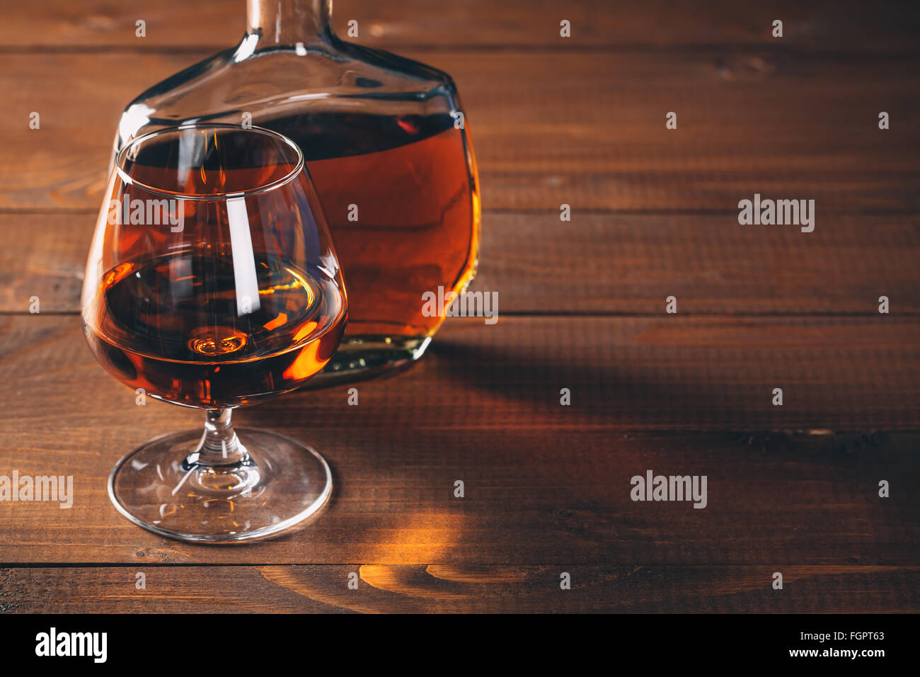 Bicchieri di cognac e bottiglia sul tavolo di legno. Foto Stock