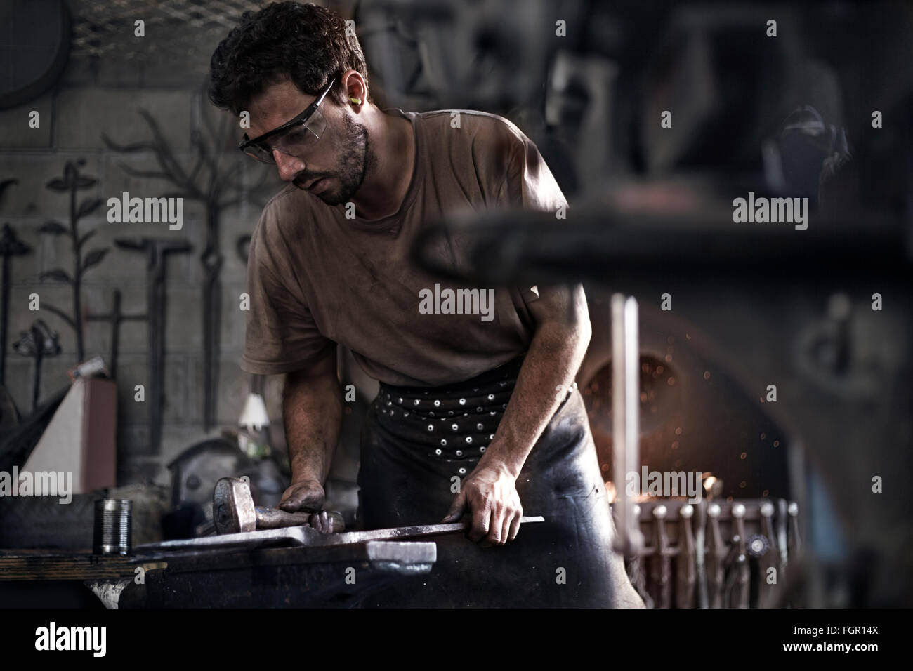 Fabbro ferro martellatura a incudine nella fucina Foto Stock