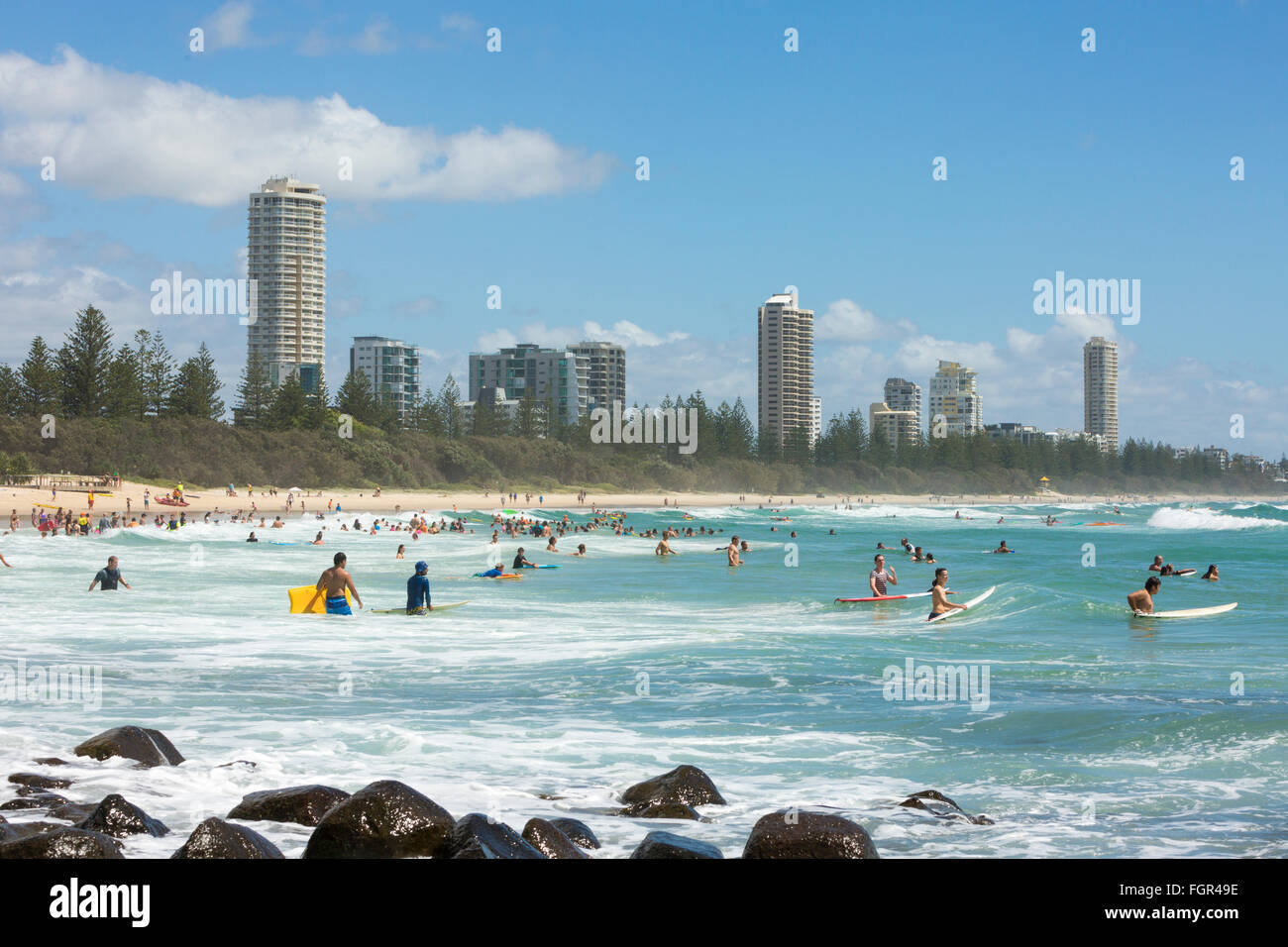 Spiaggia e costa di Burleigh Heads sulla Gold Coast, Queensland, Australia, gente che nuota e fa surf nell'oceano con alti edifici Foto Stock