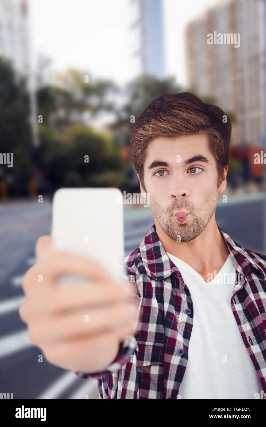 Immagine composita dell'uomo facendo faccia tenendo selfie Foto Stock
