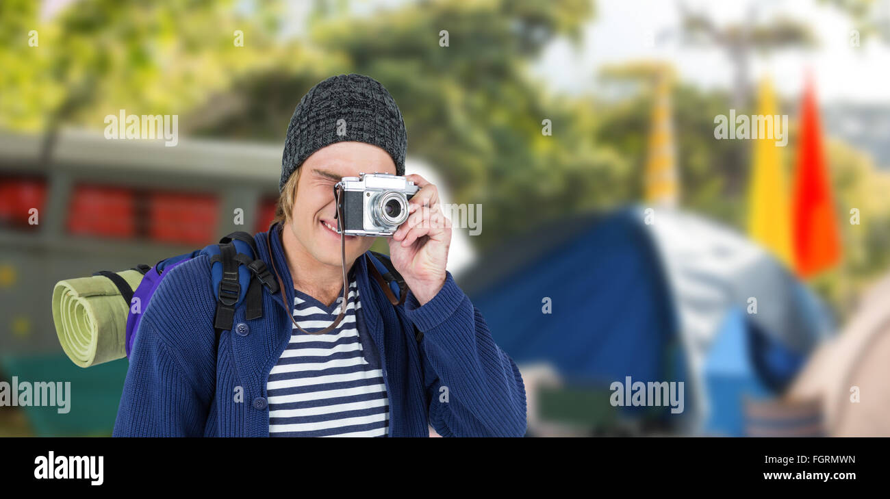 Immagine composita di backpacker hipster scattare foto con una fotocamera retrò Foto Stock