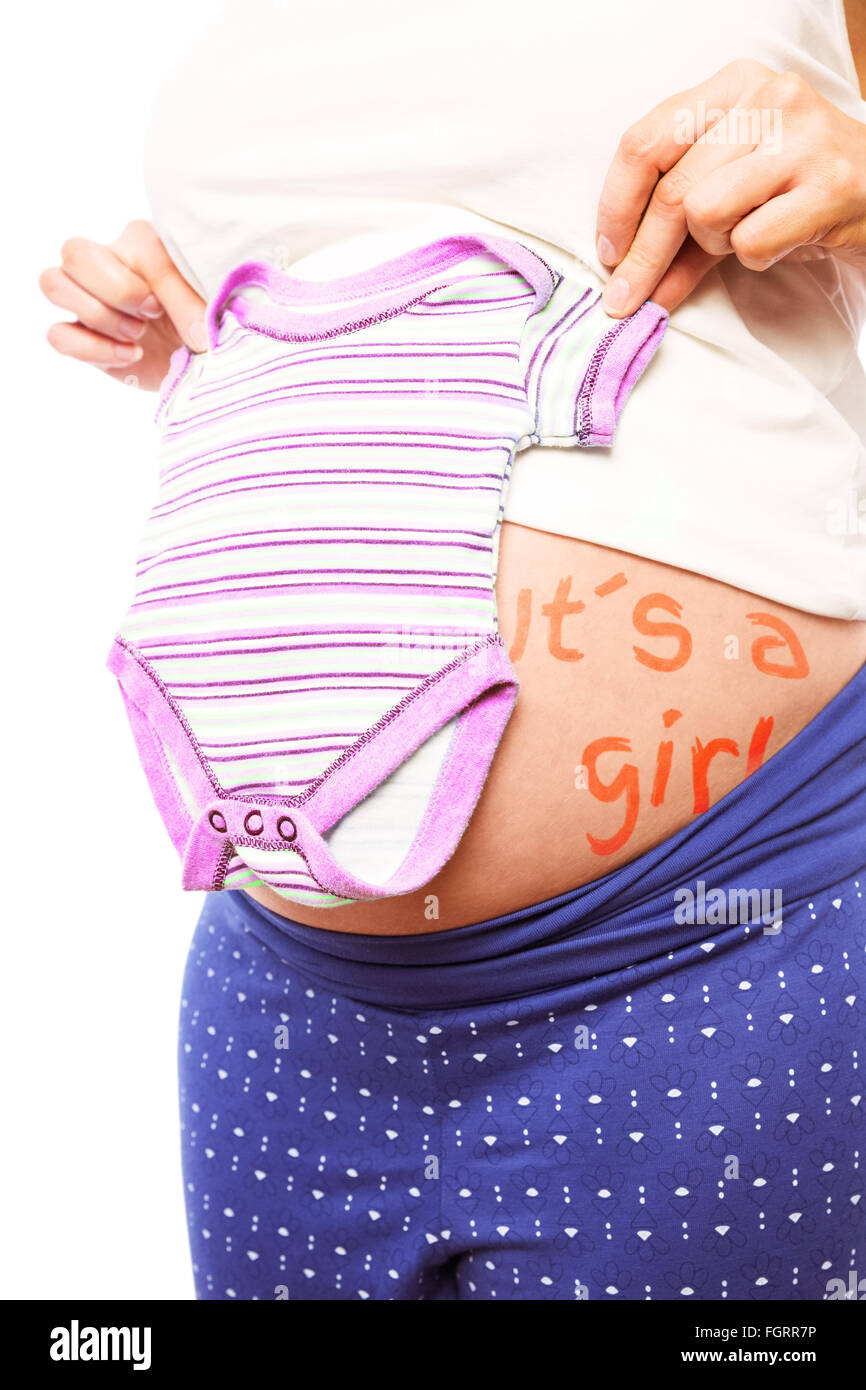 Donna incinta holding pigiami oltre il suo ventre Foto Stock