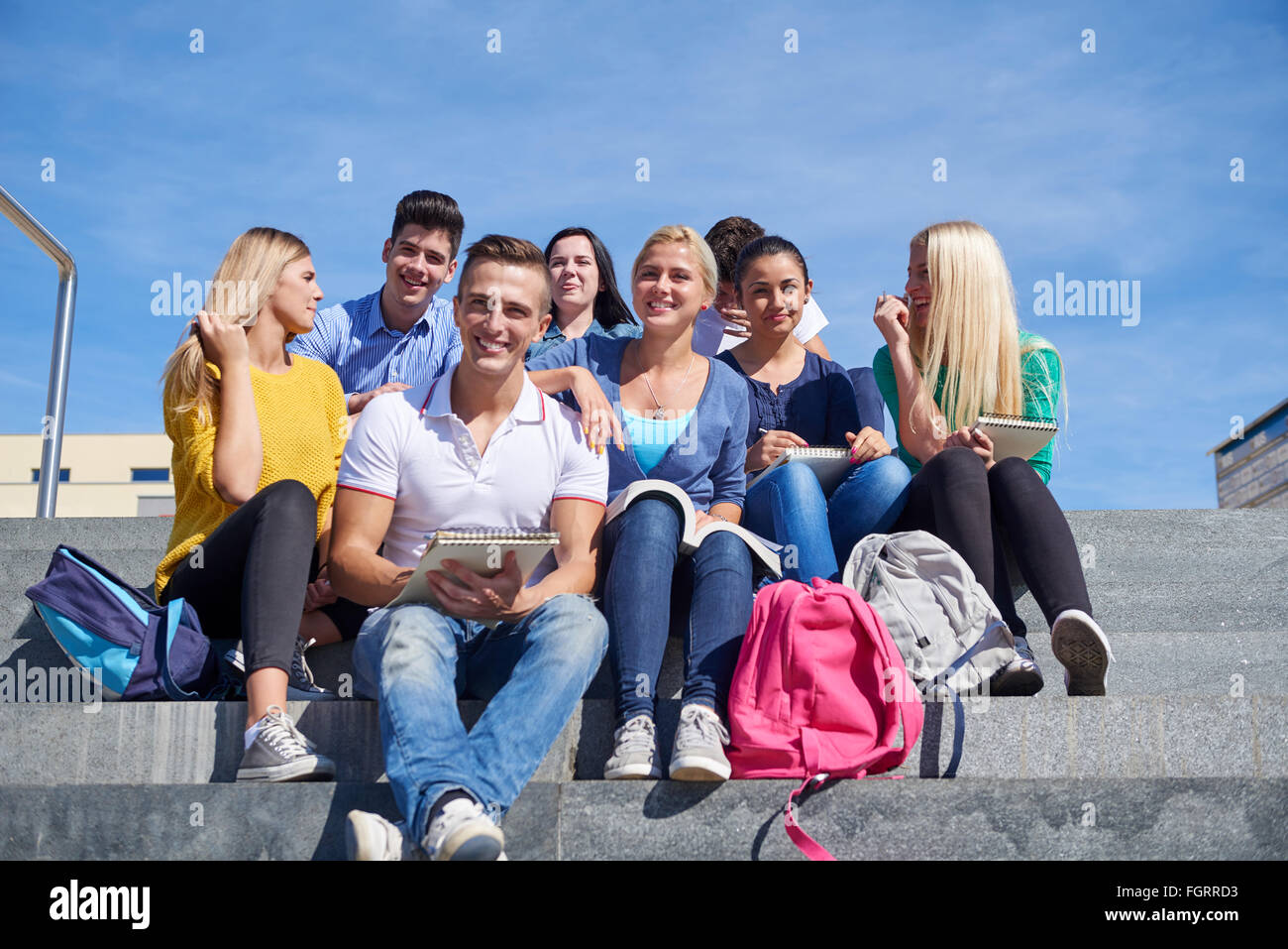 Gli studenti al di fuori seduta sui gradini Foto Stock