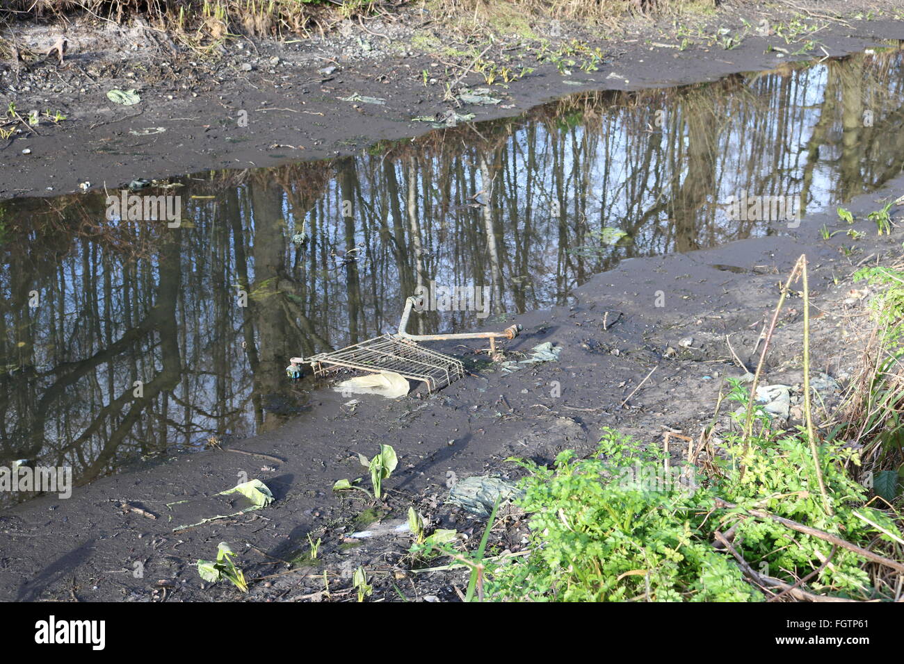 Un carrello per supermercati è visto in Basingstoke Canal a Woking, Surrey dopo che esso è stato scaricato pronto per lavori di riparazione. Foto Stock