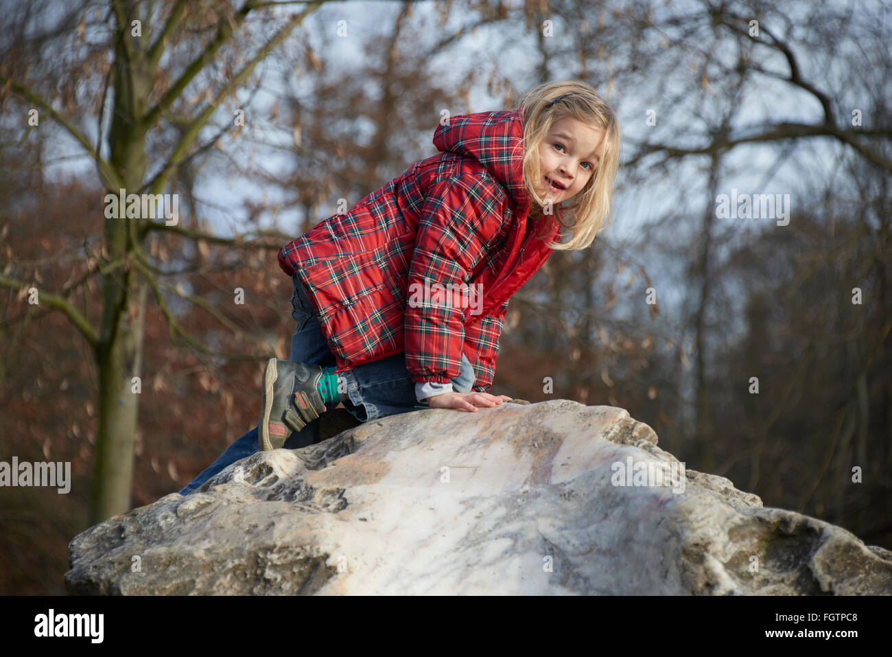 Bambino ragazza bionda in posa su una roccia Foto Stock