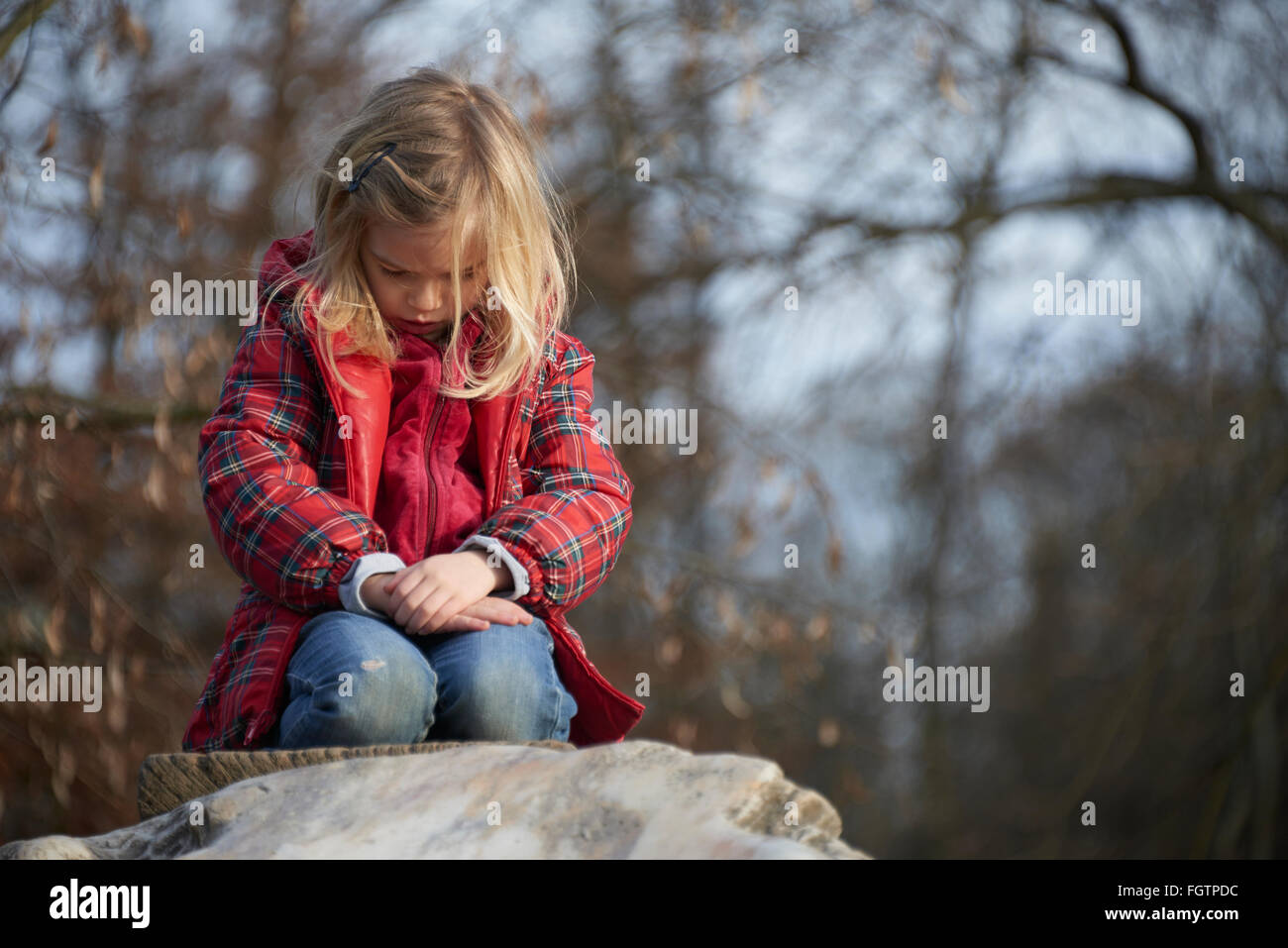 Bambino ragazza bionda in posa su una roccia Foto Stock