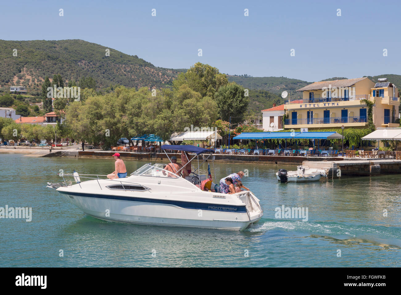 Platanias, Tessaglia, Grecia. Famiglia su un escursione di lasciare il porto con la loro imbarcazione a motore. Foto Stock