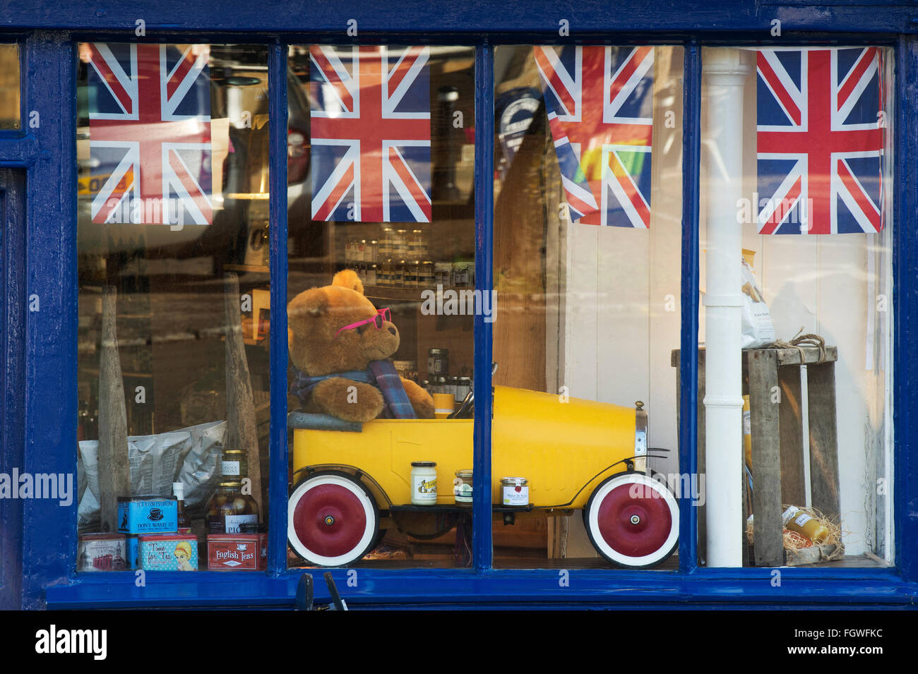 Orsacchiotto di peluche in una vettura di stagno in un negozio a Burford finestra. Cotswolds, Oxfordshire, Inghilterra Foto Stock