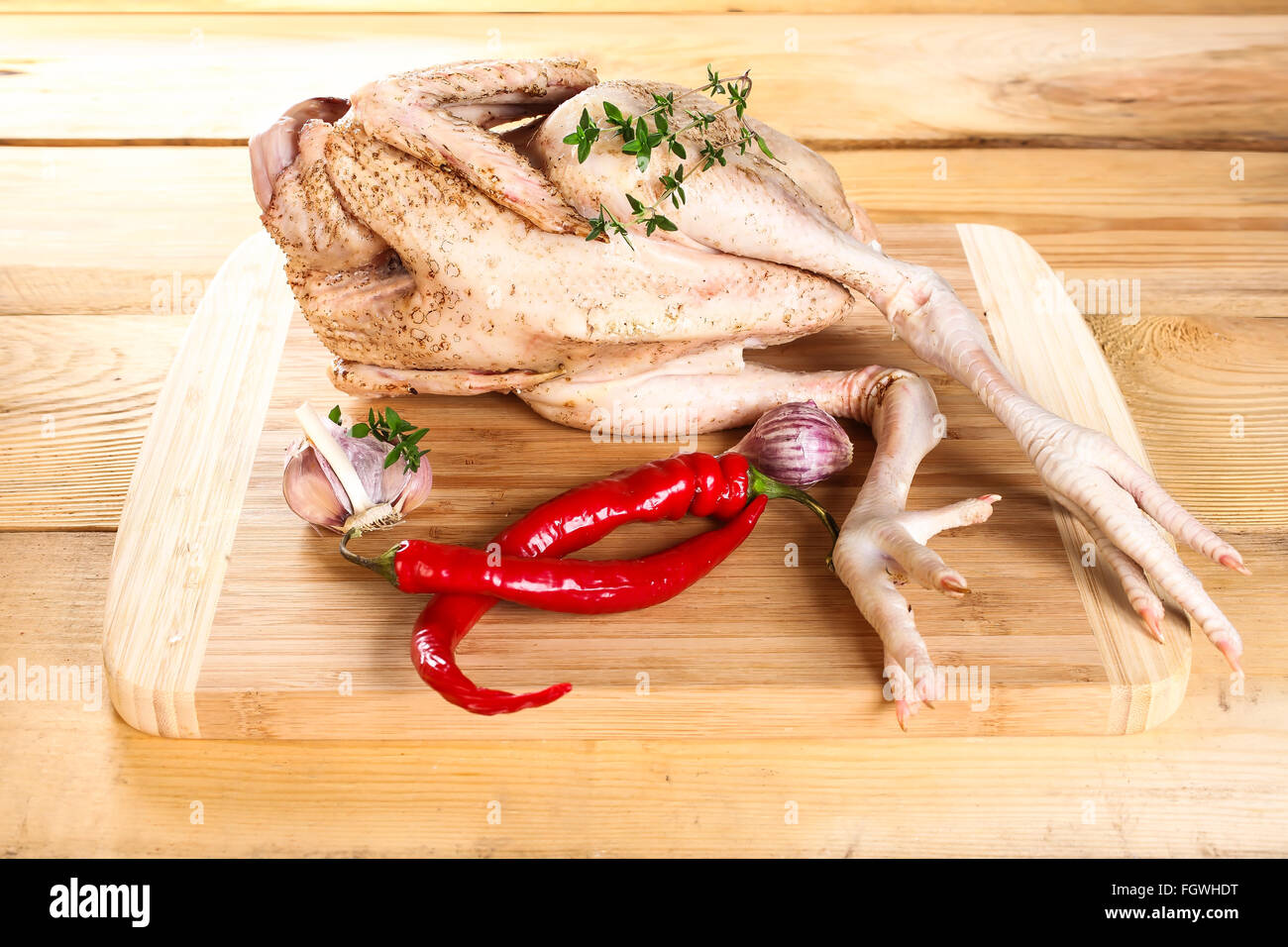 Crudo fresco carcassa di pollo tavola di legno con pepe Foto Stock