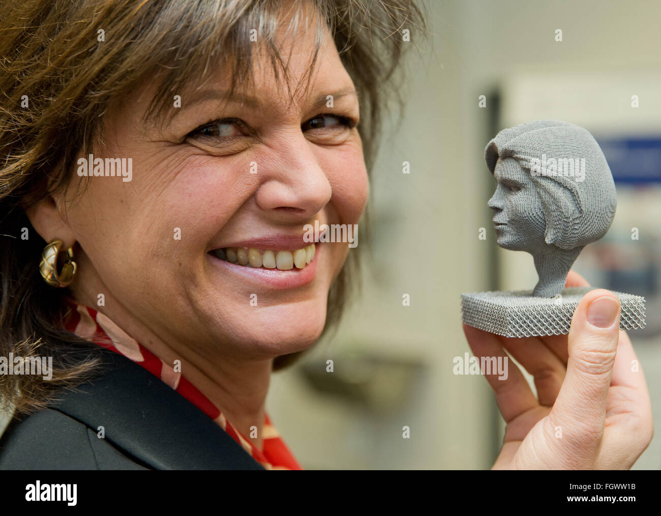 Fuerth, Germania. Il 22 febbraio, 2016. Ilse Aigner, ministro della scienza dello stato tedesco della Baviera, sorregge un busto di titanio nella sua somiglianza durante una visita all'ingegneria di processo di application center (VerTec) in Fuerth, Germania, 22 febbraio 2016. Il busto è stato fabbricato utilizzando un fascio di elettroni elaborazione di fusione. Foto: DANIEL KARMANN/dpa/Alamy Live News Foto Stock