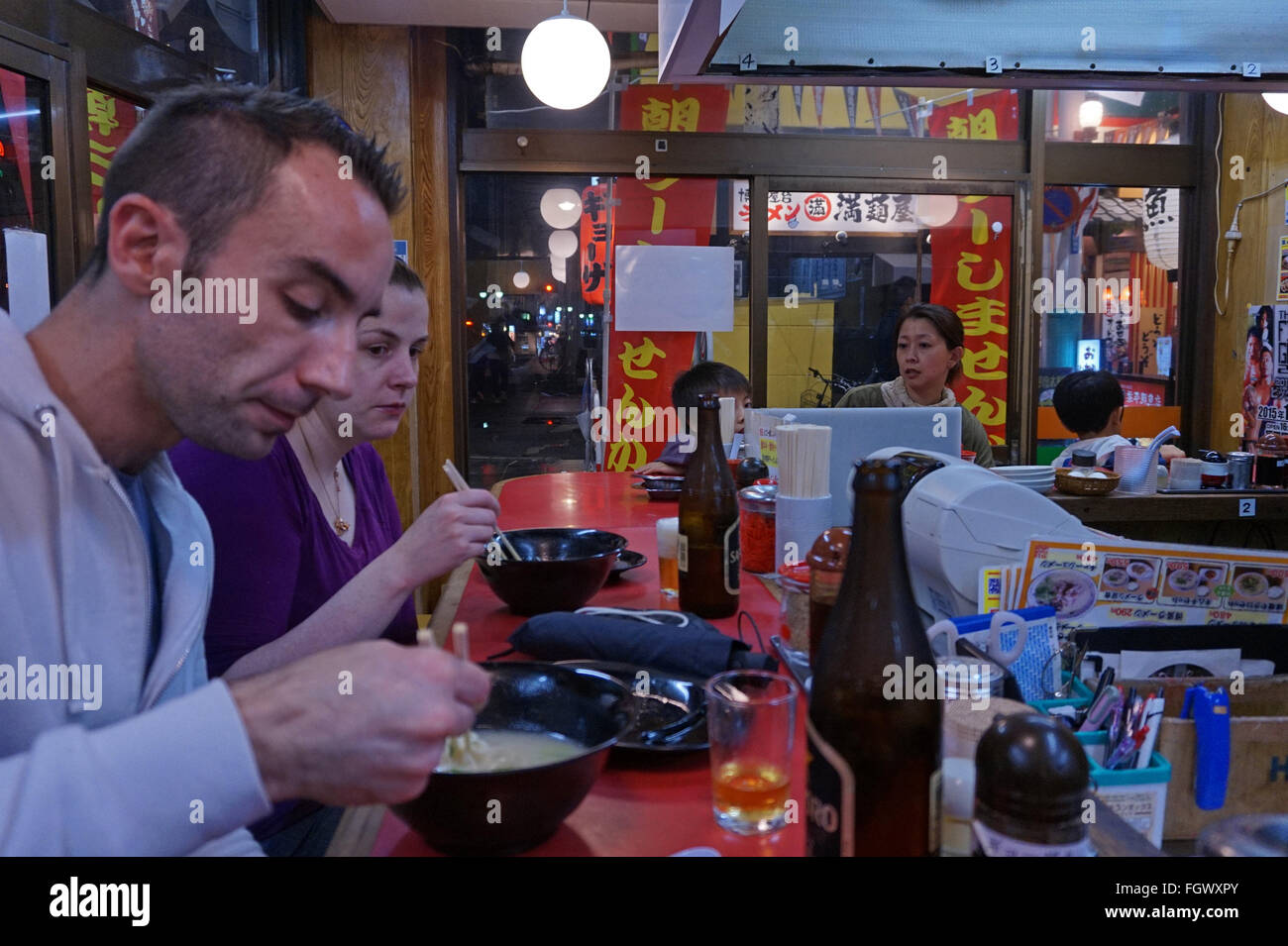 I turisti mangiare tagliatelle in un bar per il pranzo, Fukuoka, Giappone Foto Stock