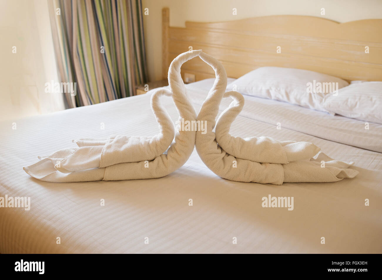 Design della camera da letto con cigni dalla decorazione asciugamano sul lettino Foto Stock