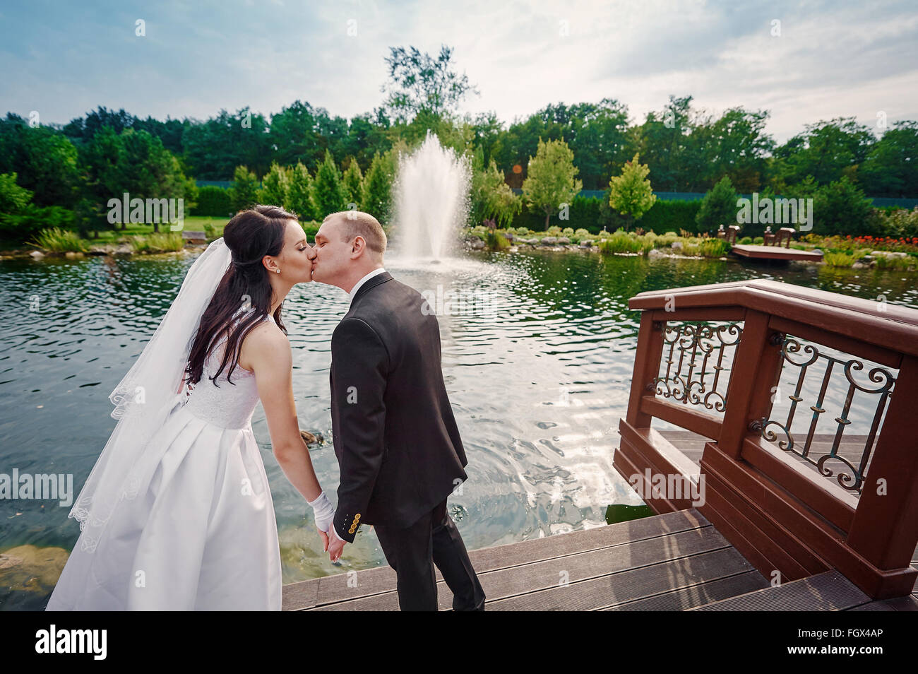 Lo sposo e la sposa a piedi vicino al lago il giorno delle nozze Foto Stock