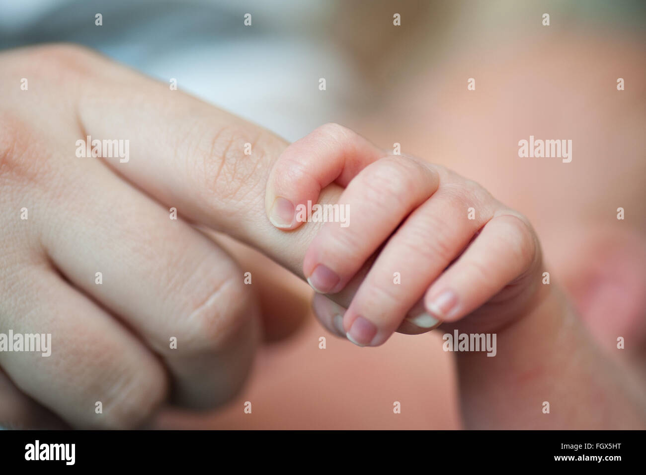Close-up di baby la mano che tiene la madre del dito con tenerezza Foto Stock